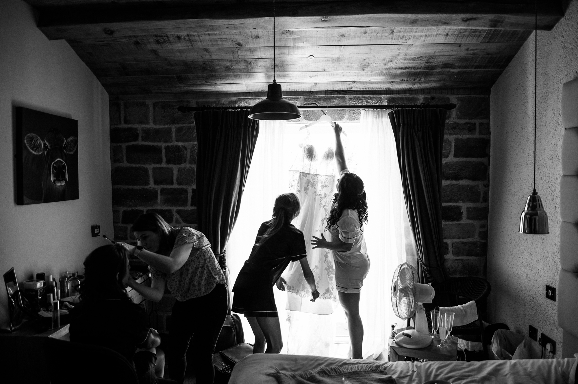 bride silhouette reaching for her hanging wedding dress