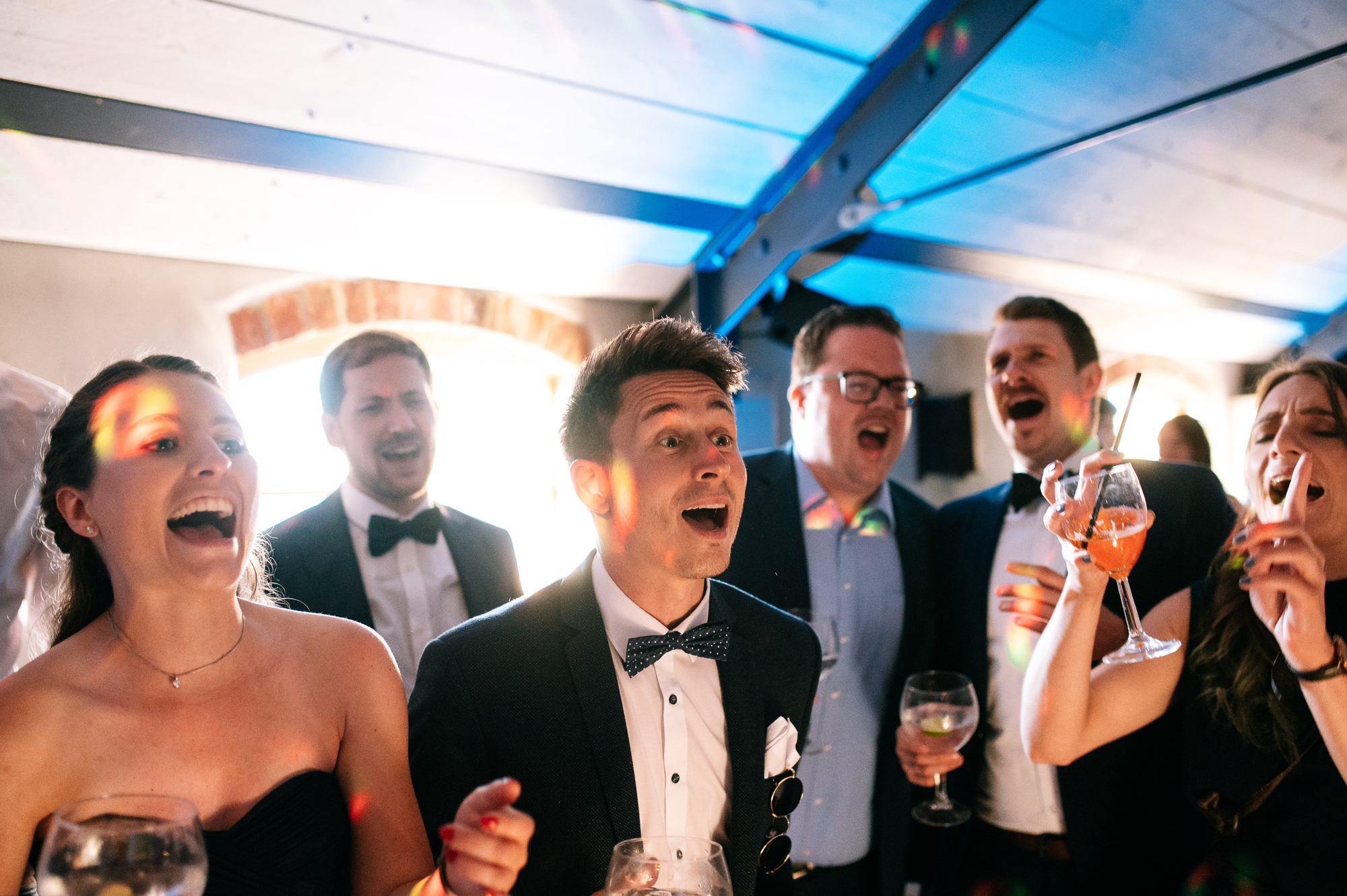 men in tuxedos singing on the dancefloor