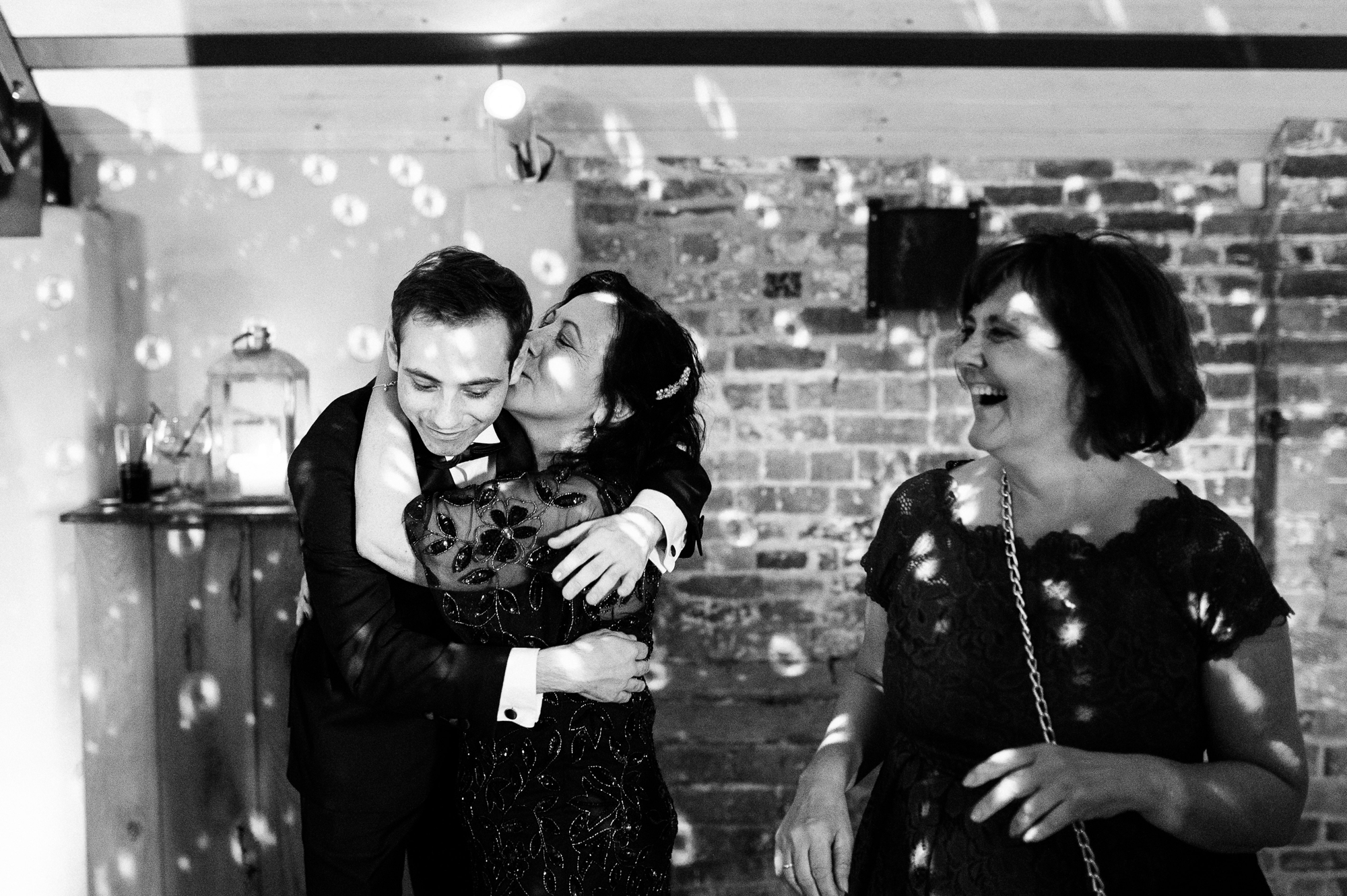 brides mum giving her son a kiss