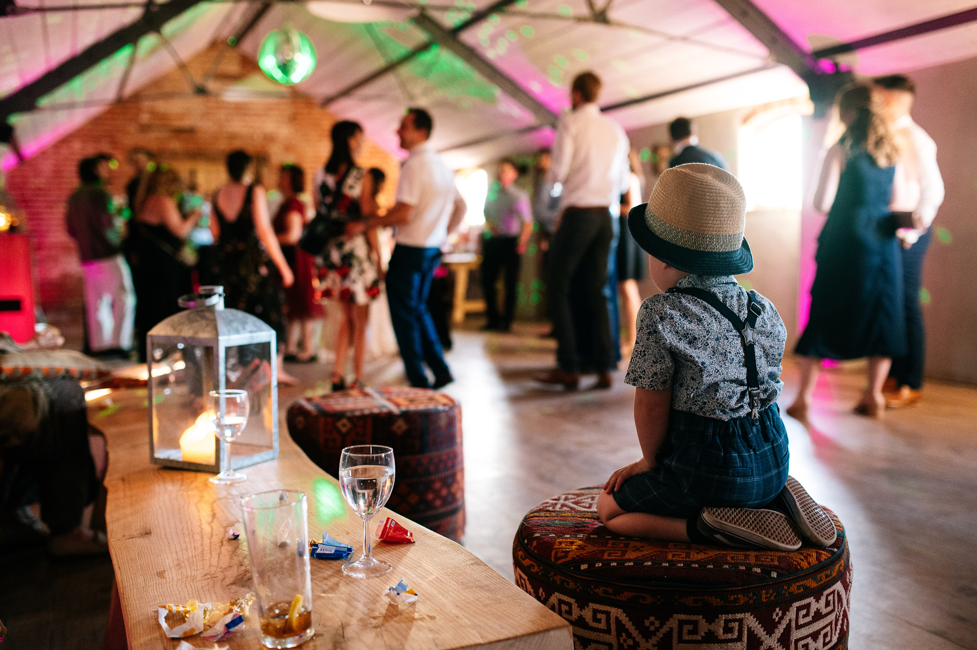 little boy in a straw hat watching the dancefloor