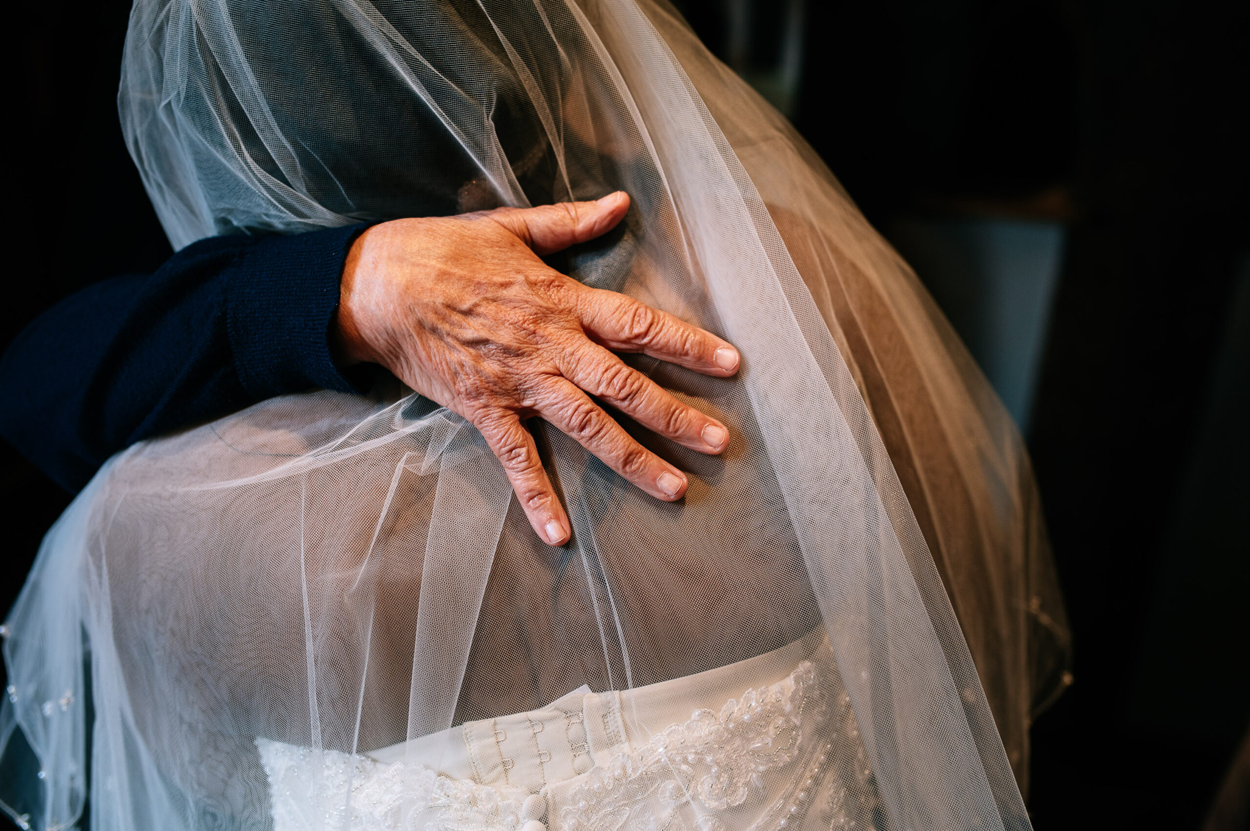 closeup of a hand giving the bride a hug