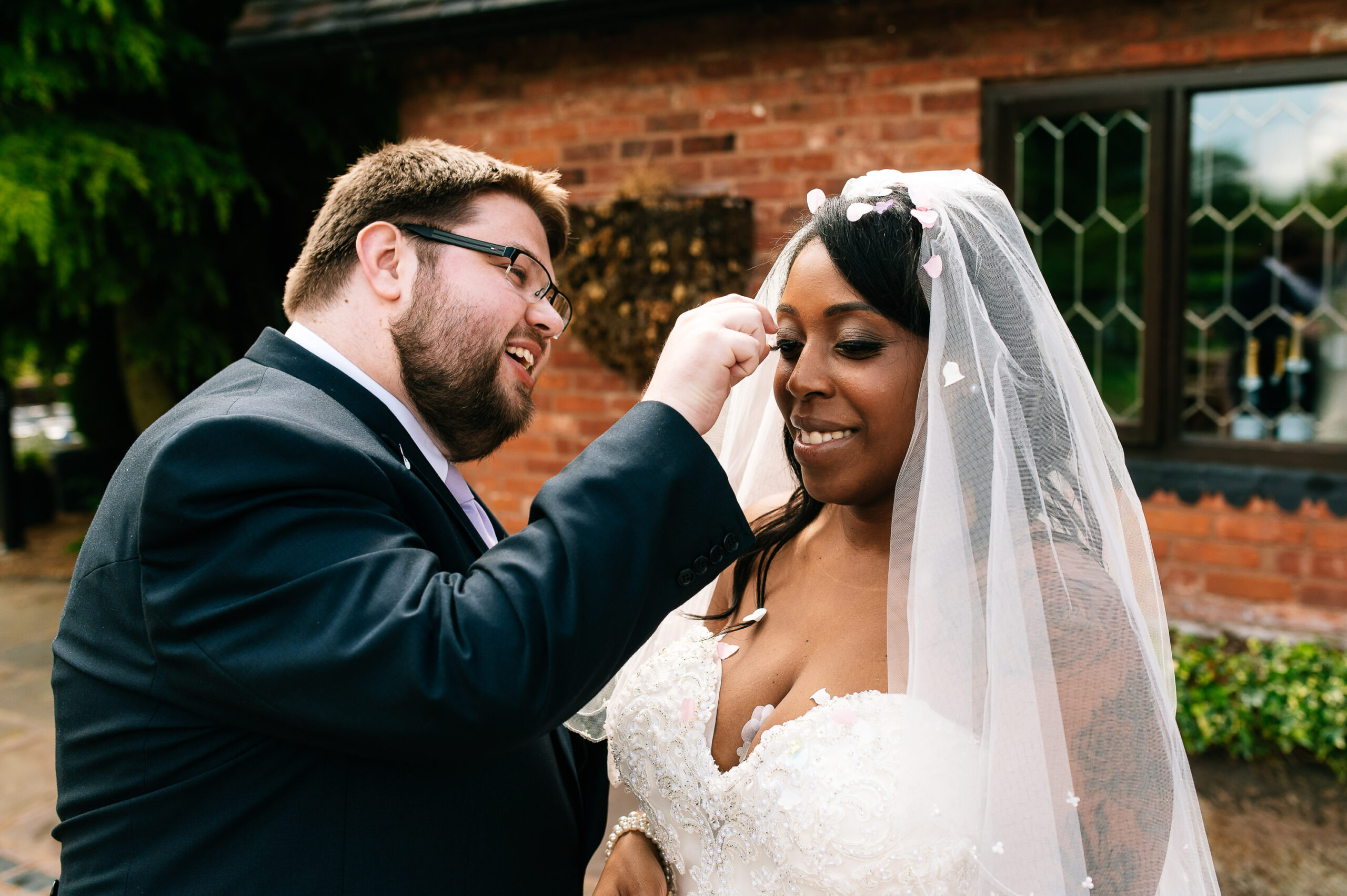 groom picking confetti off bride's eyelash