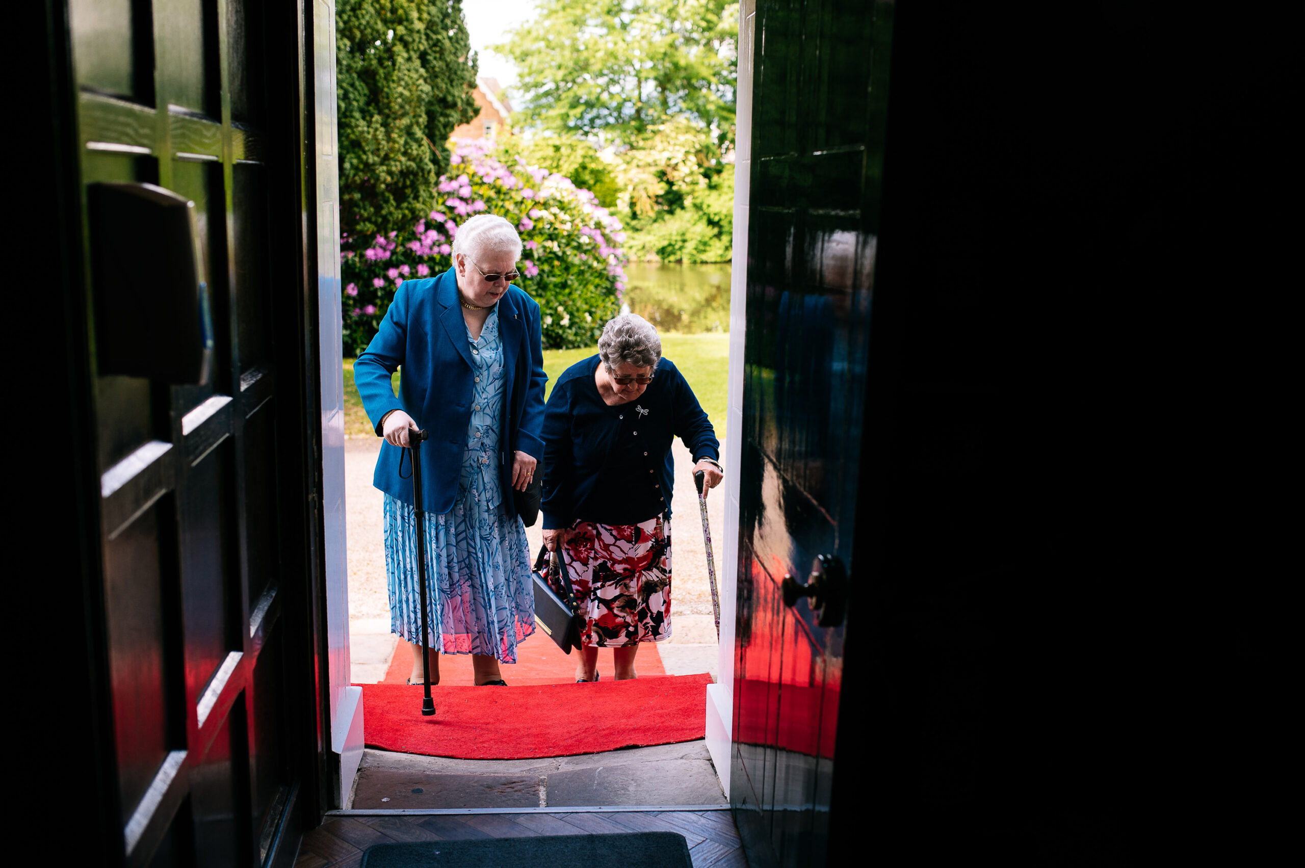 two elderly wedding guests entering the venue