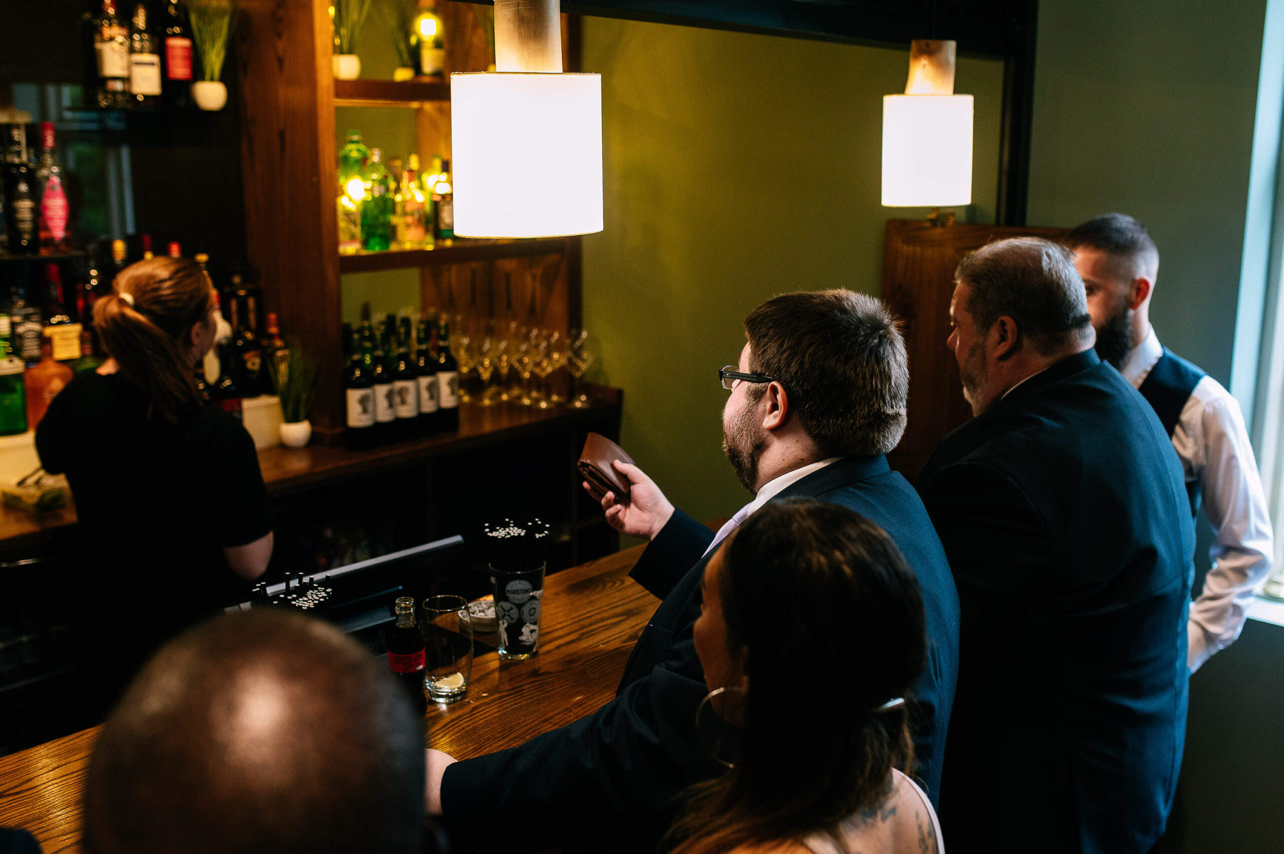 groom offering his wallet to the bar tender