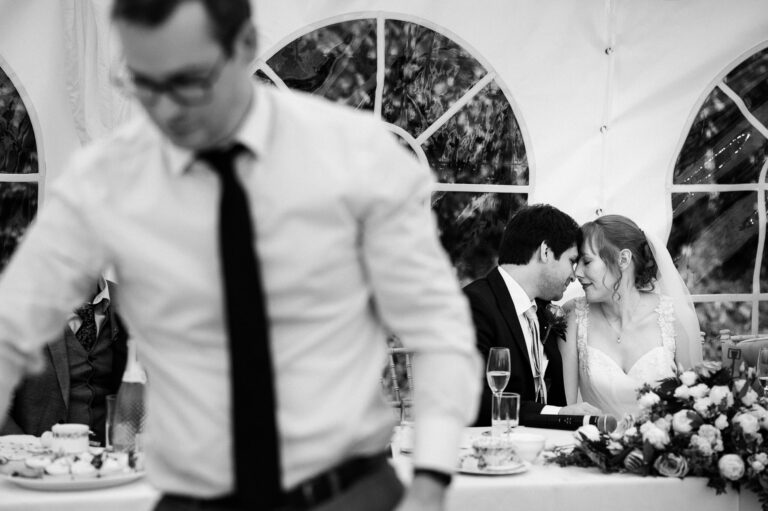 bride and groom having an intimate moment during their wedding breakfast