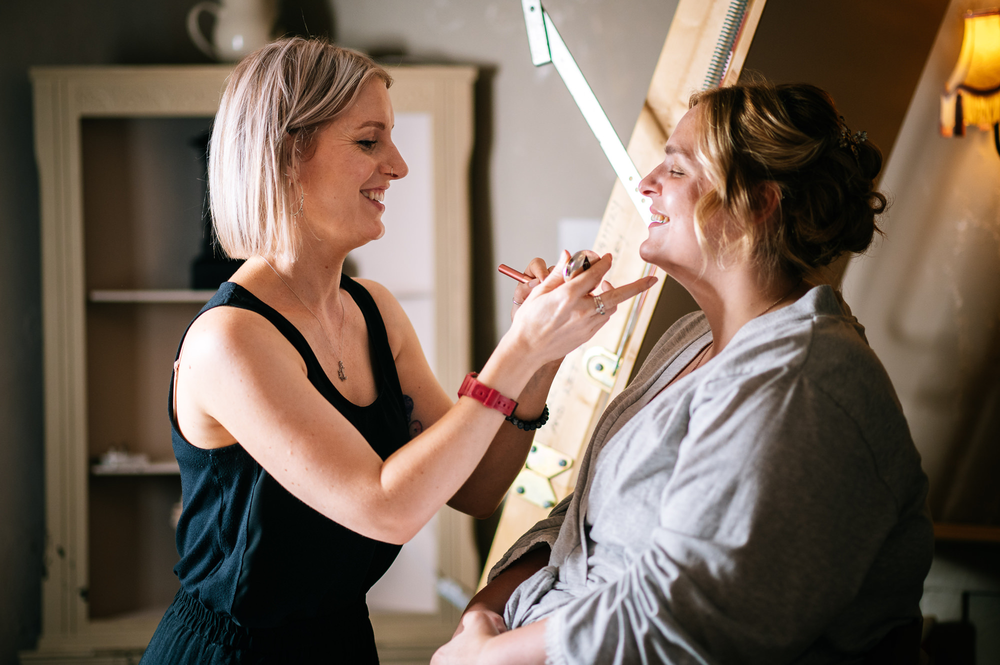 smiling bride having her makeup done