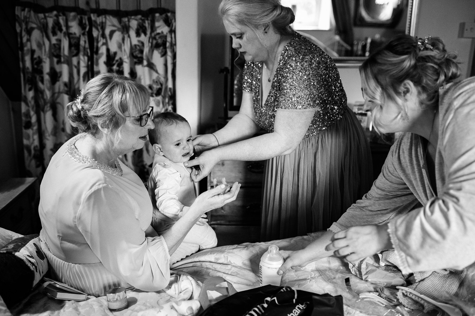 three women helping to calm a crying baby