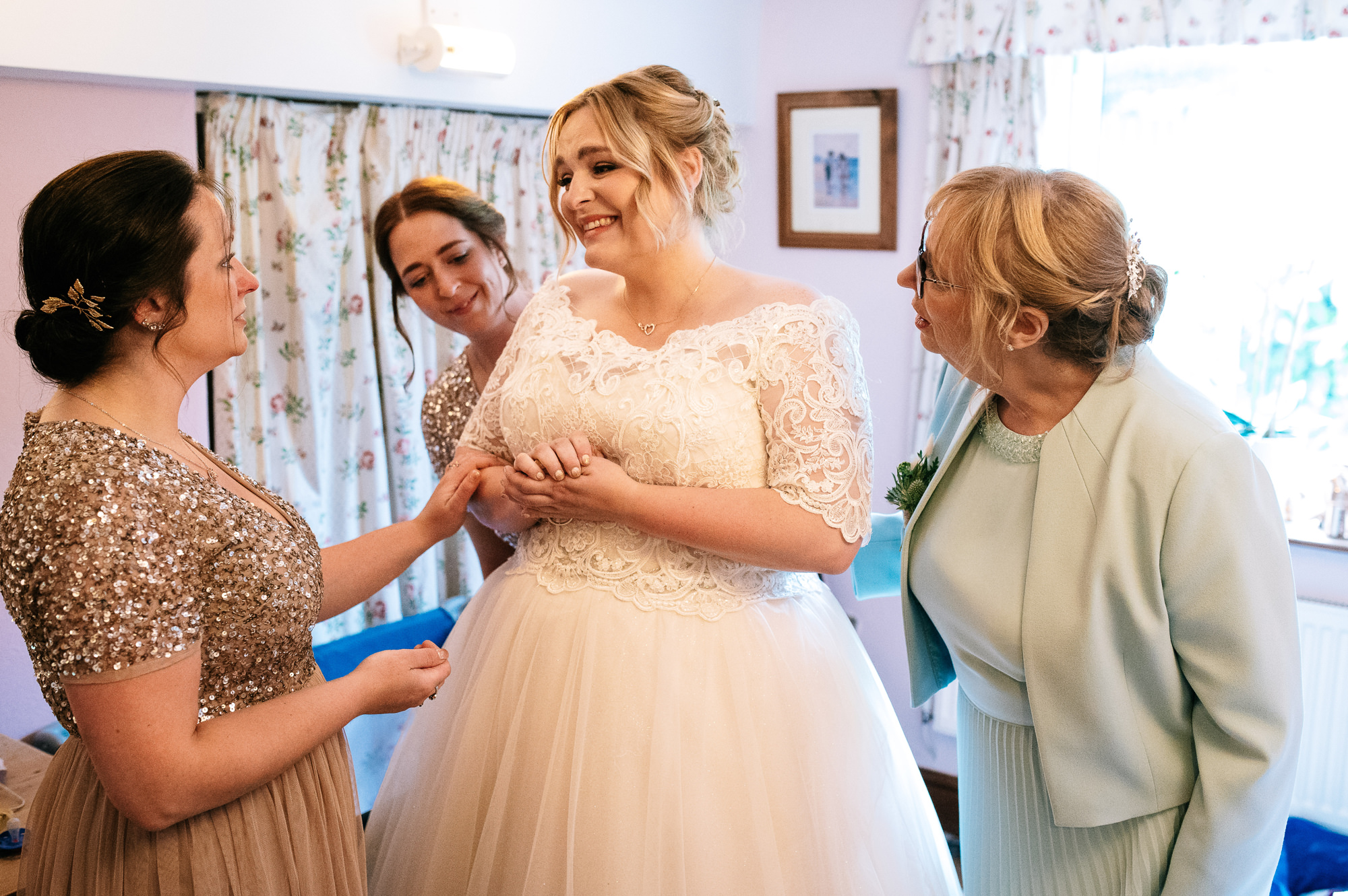 emotional bride getting into her wedding dress
