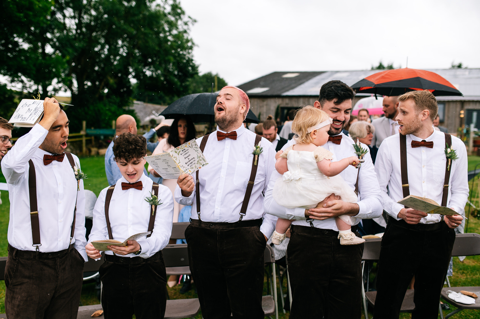 groomsmen singing during outdoor ceremony