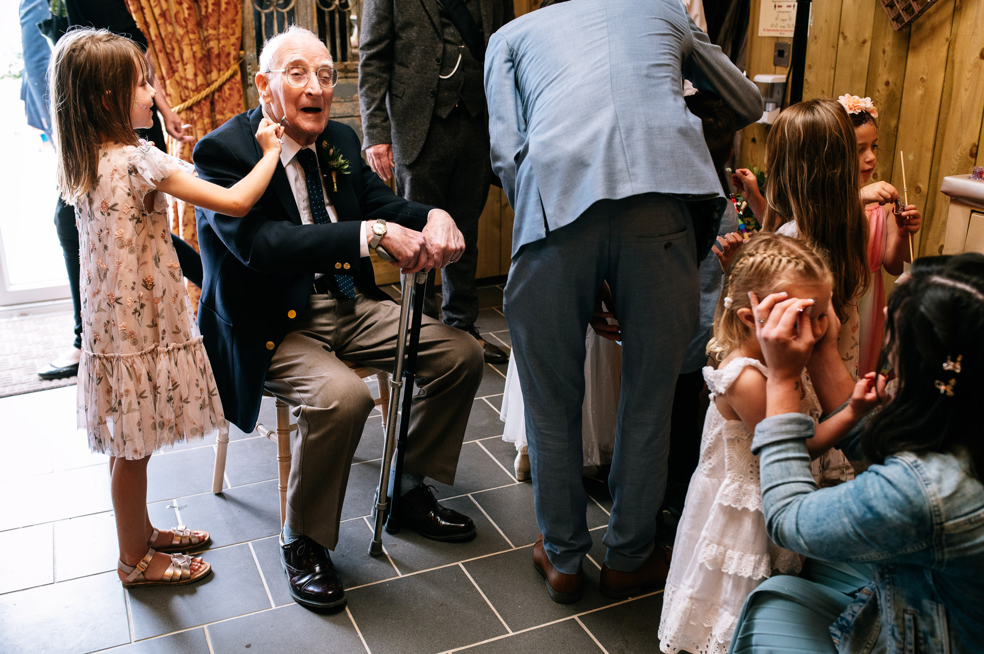 girl putting facepaint on an elderly gentleman
