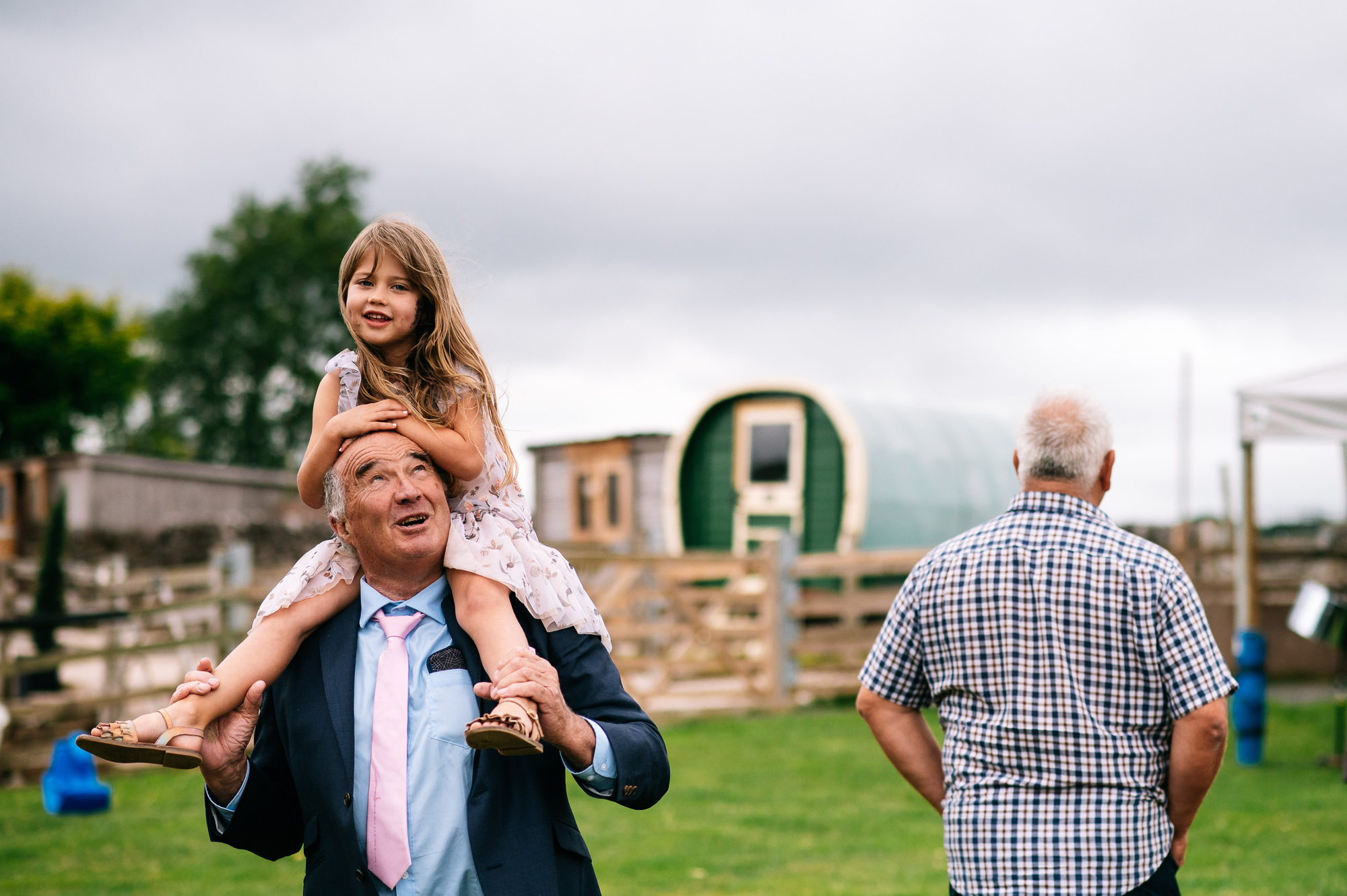 girl sat on her grandads shoulders