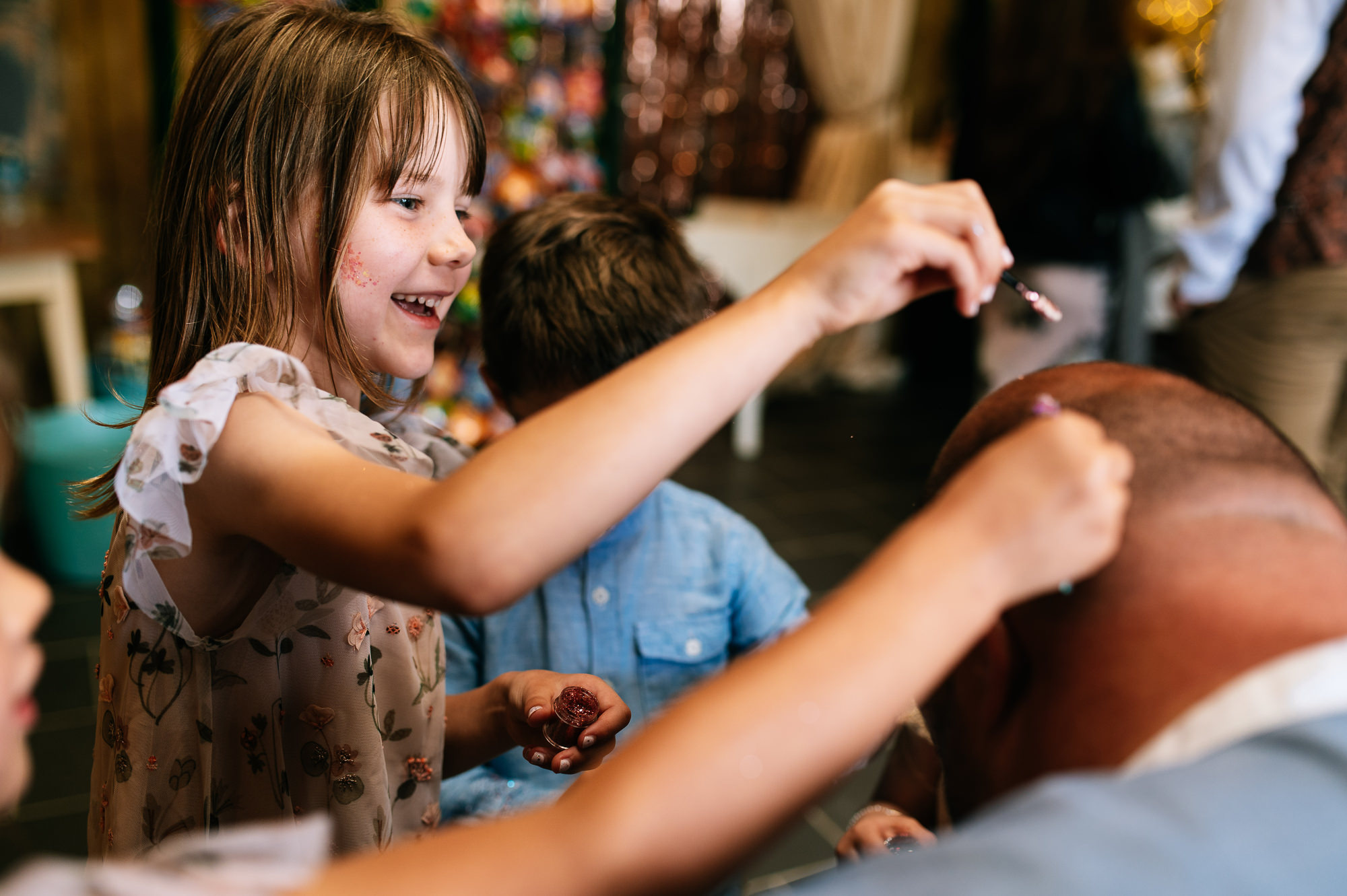 laughing girl putting glitter on a mans head