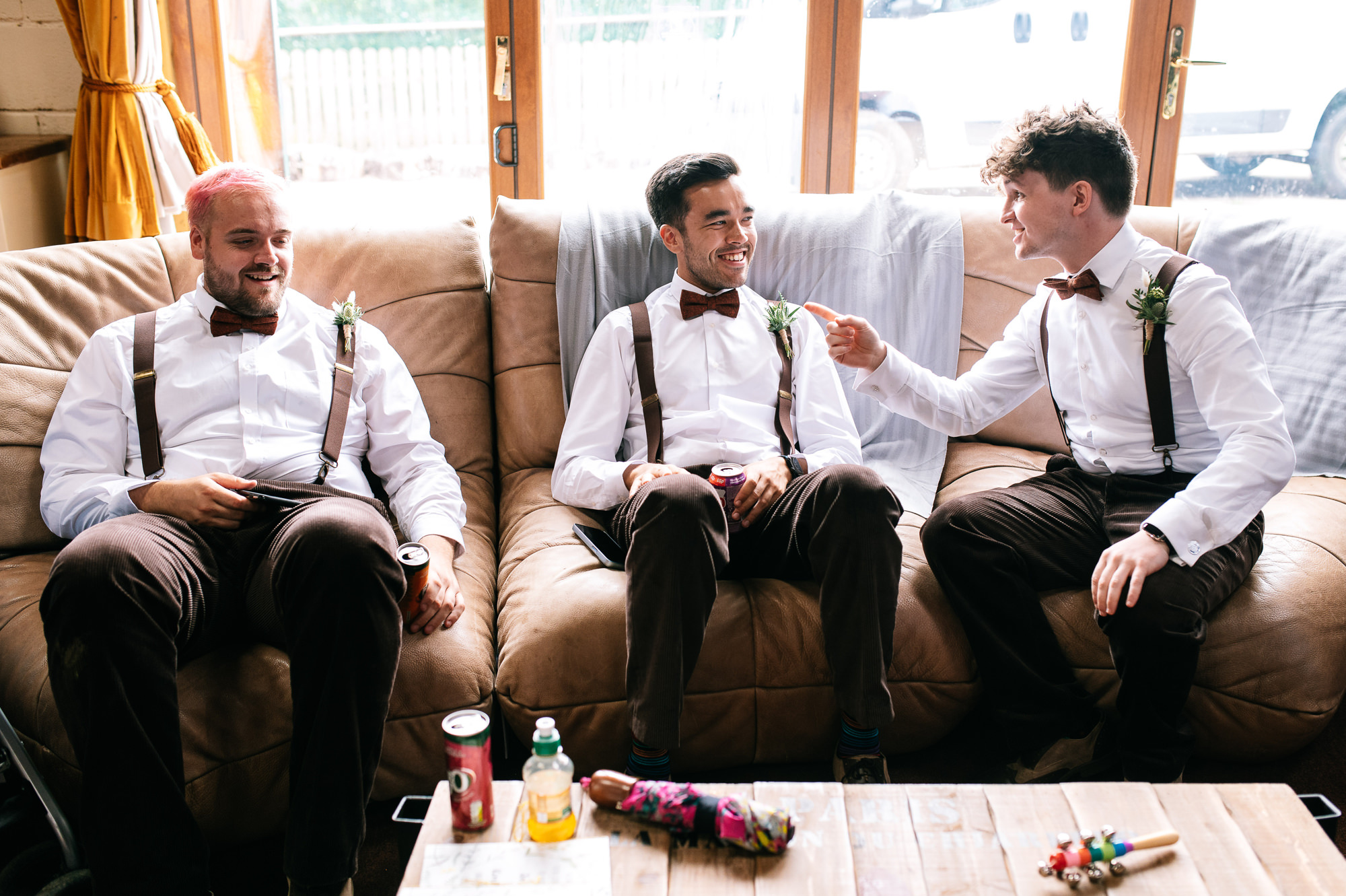 groomsmen sat together chatting on a sofa