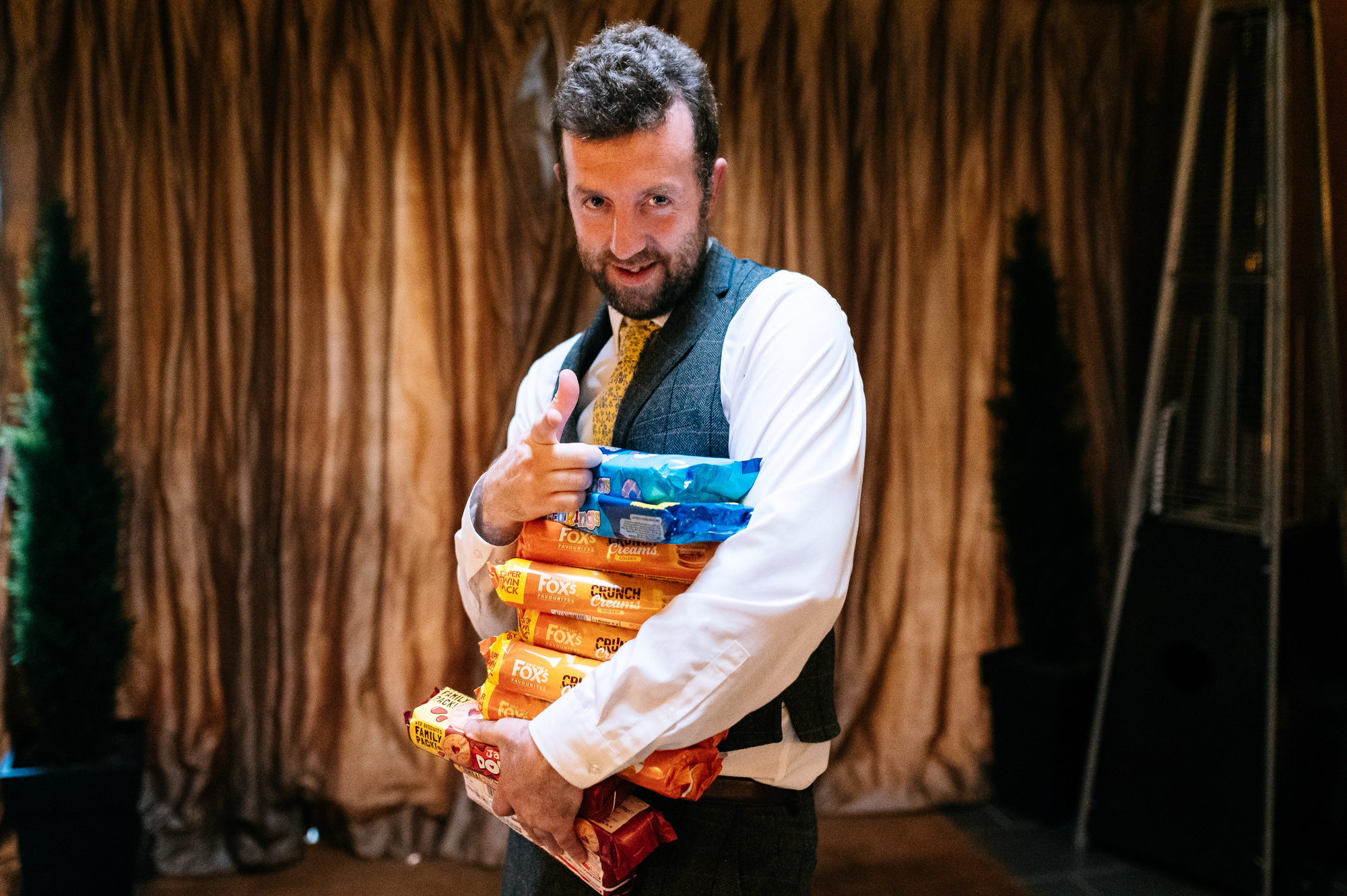 a man holding lots of packets of biscuits