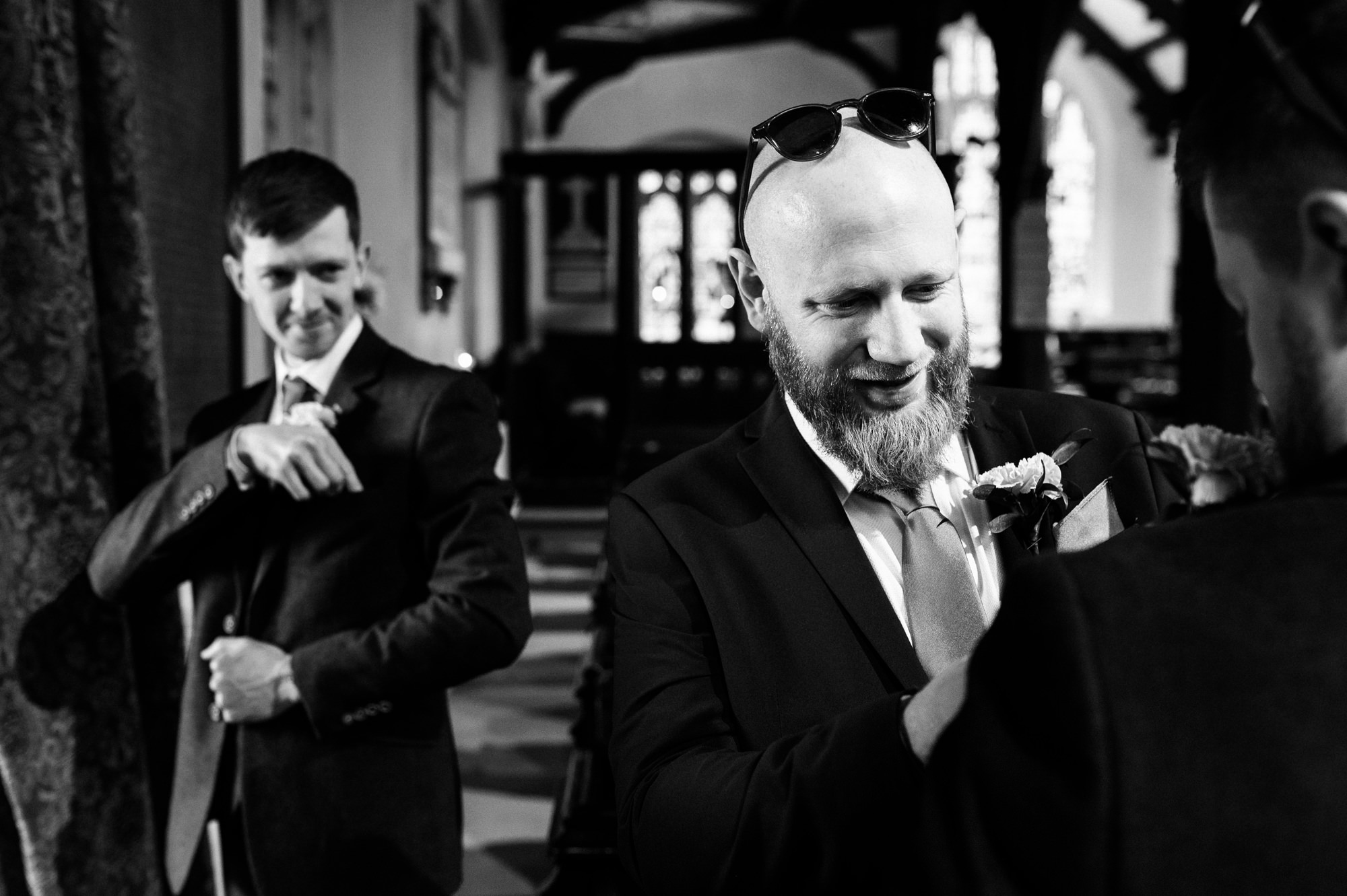 groom and bestman laughing whilst putting on button holes