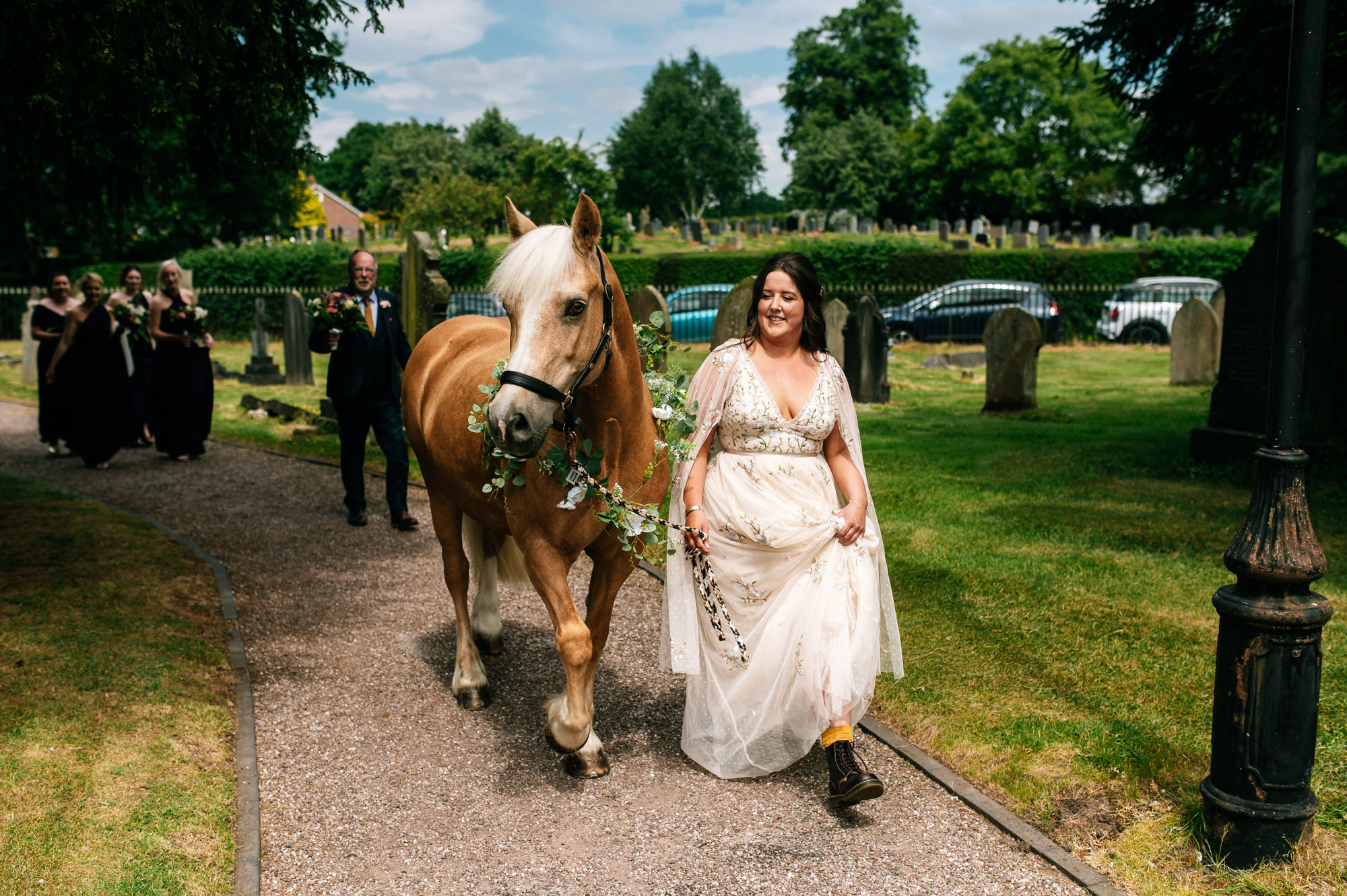 bride arriving to her wedding walking beside her horse