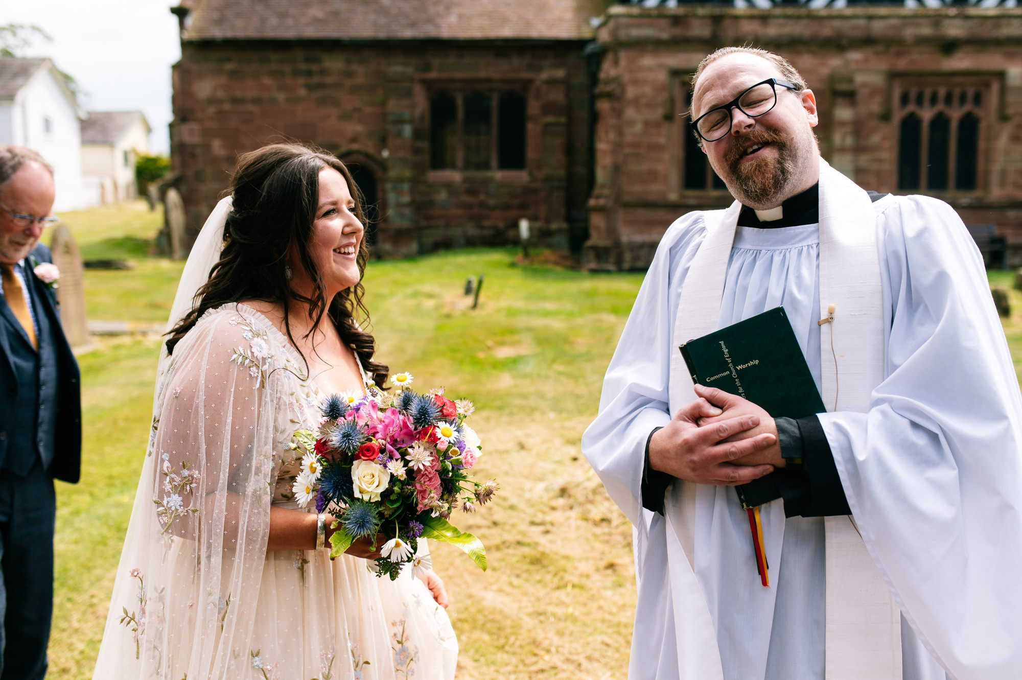 bride sharing a joke with the vicar