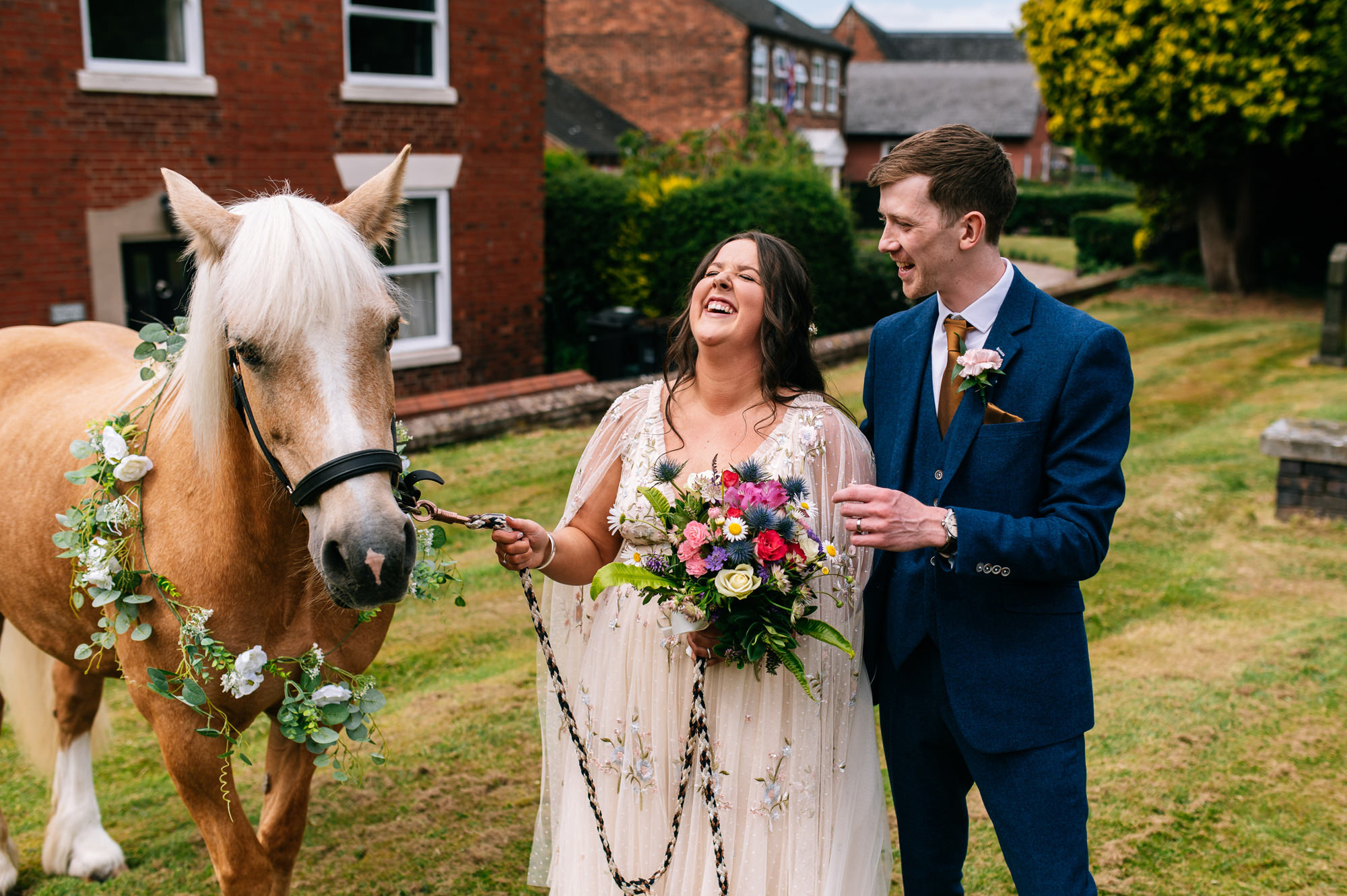 newlyweds stood together having photos with the brides horse