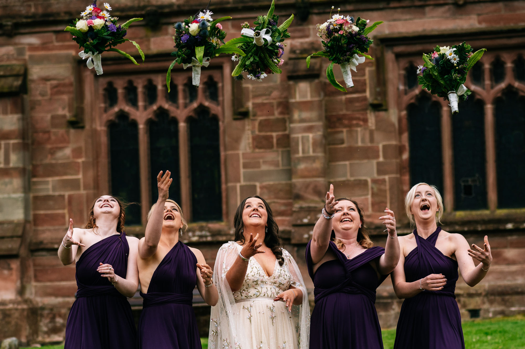 bride and bridesmaids throwing bouquets in the air together