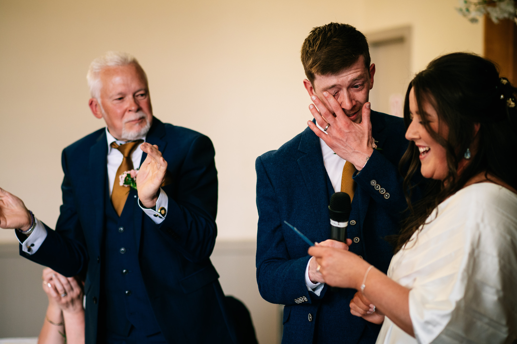 groom wiping away a tear after his father's speech