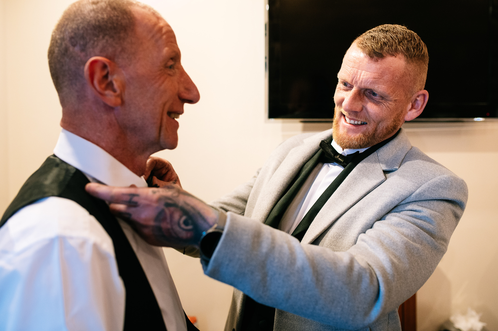 best man helping father of the bride with his bow tie
