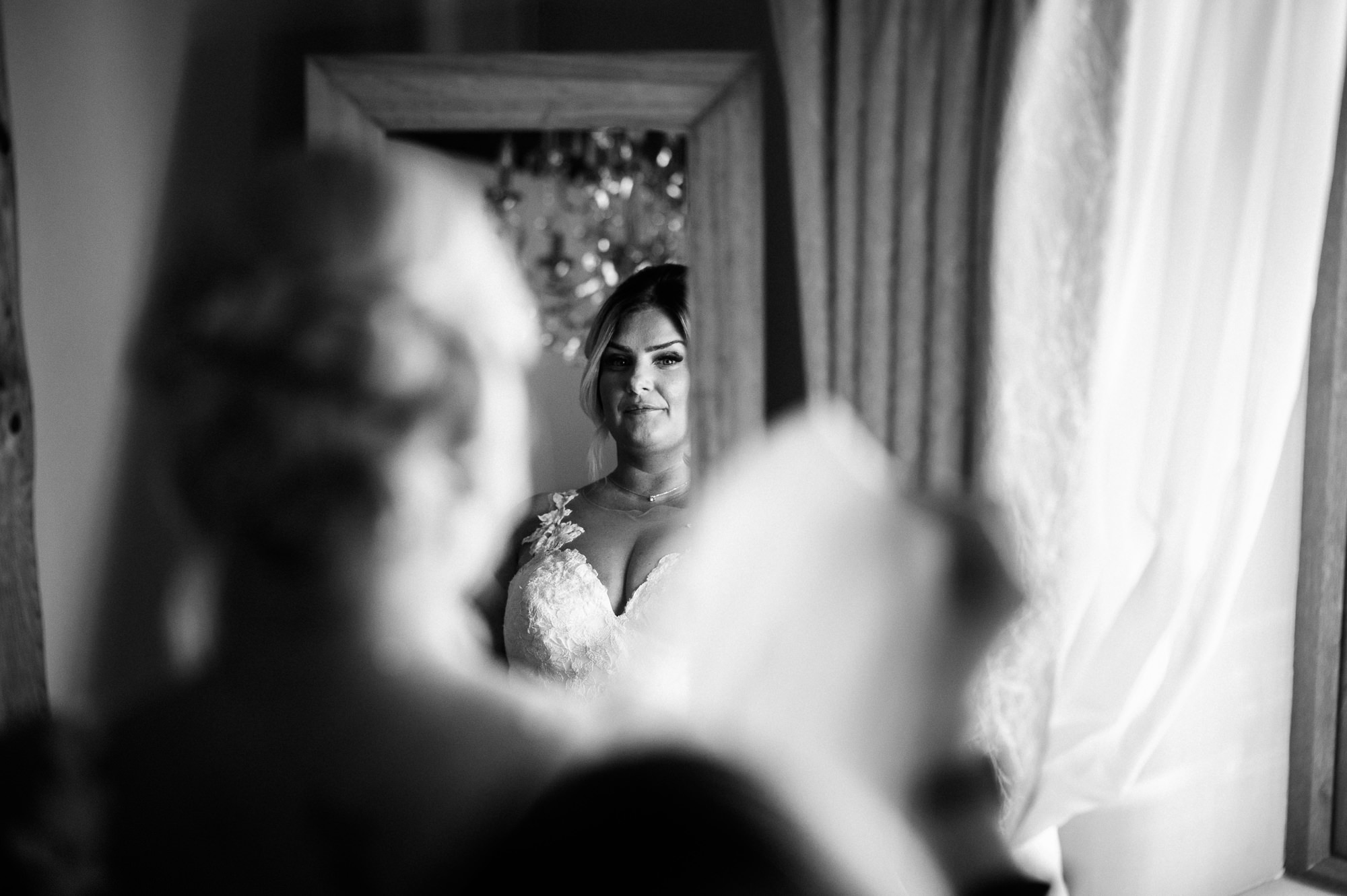 bride in her dress looking in the mirror