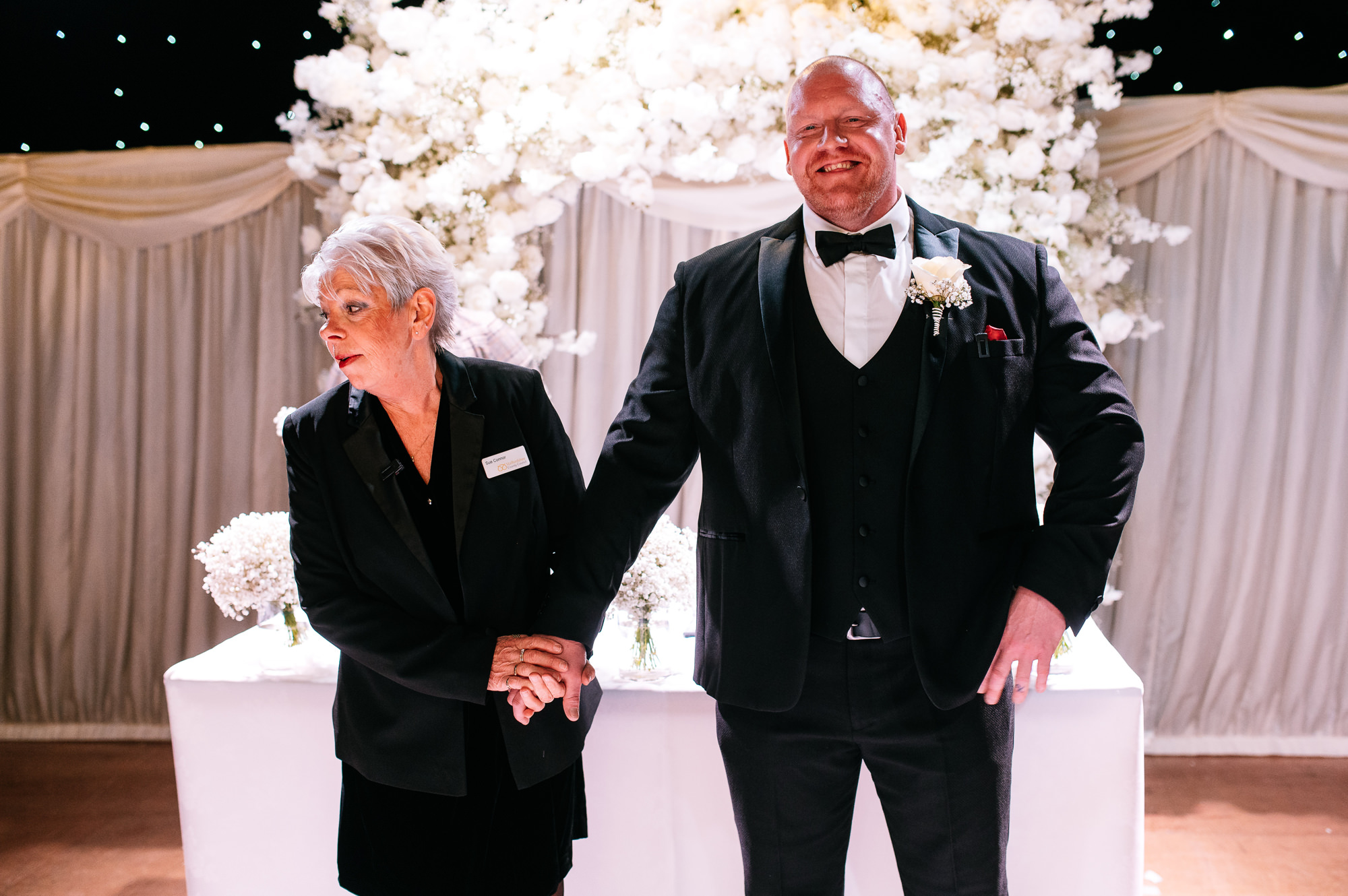 registrar holding the grooms hand before the ceremony