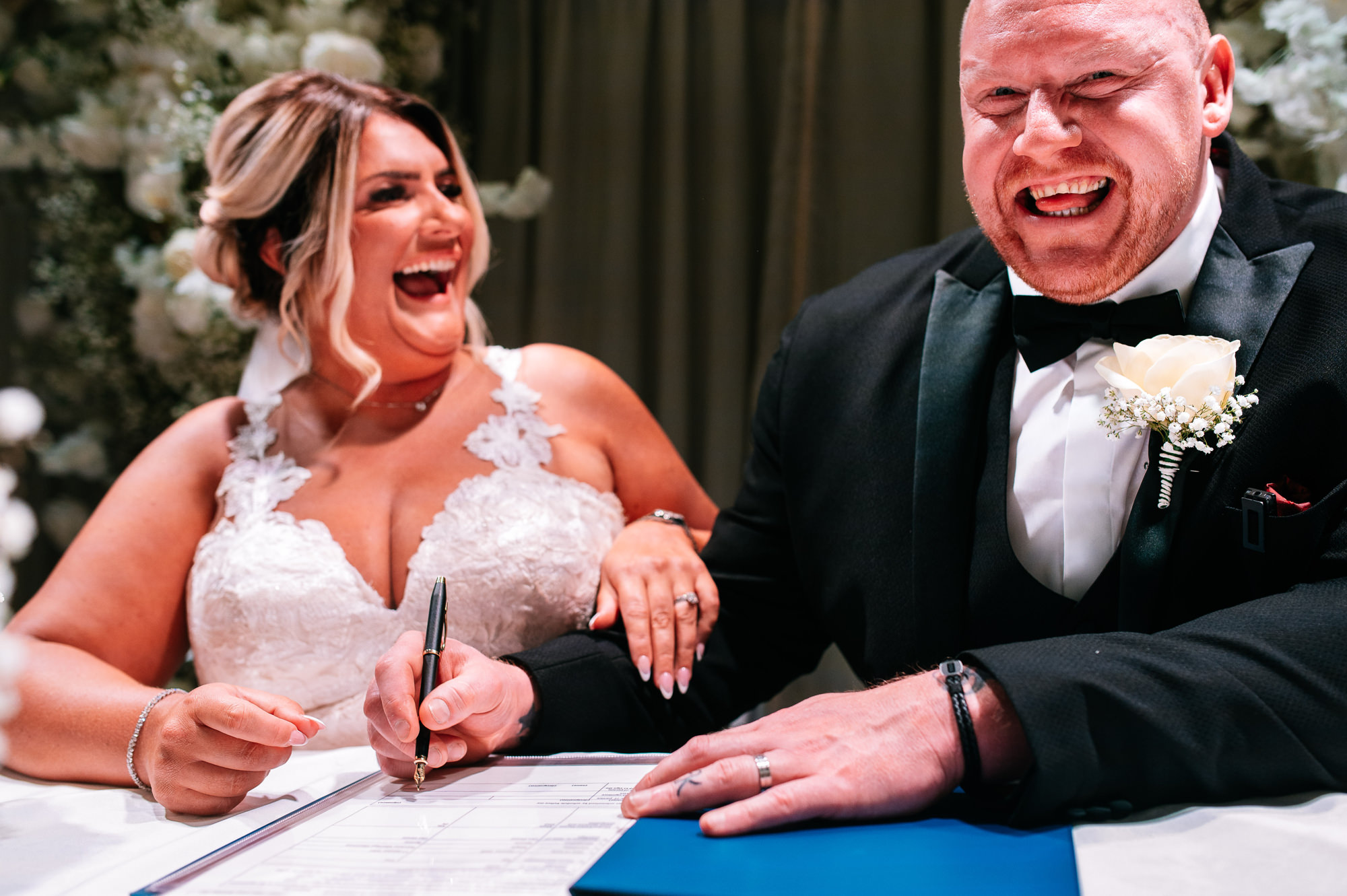 signing the marriage certificate together laughing