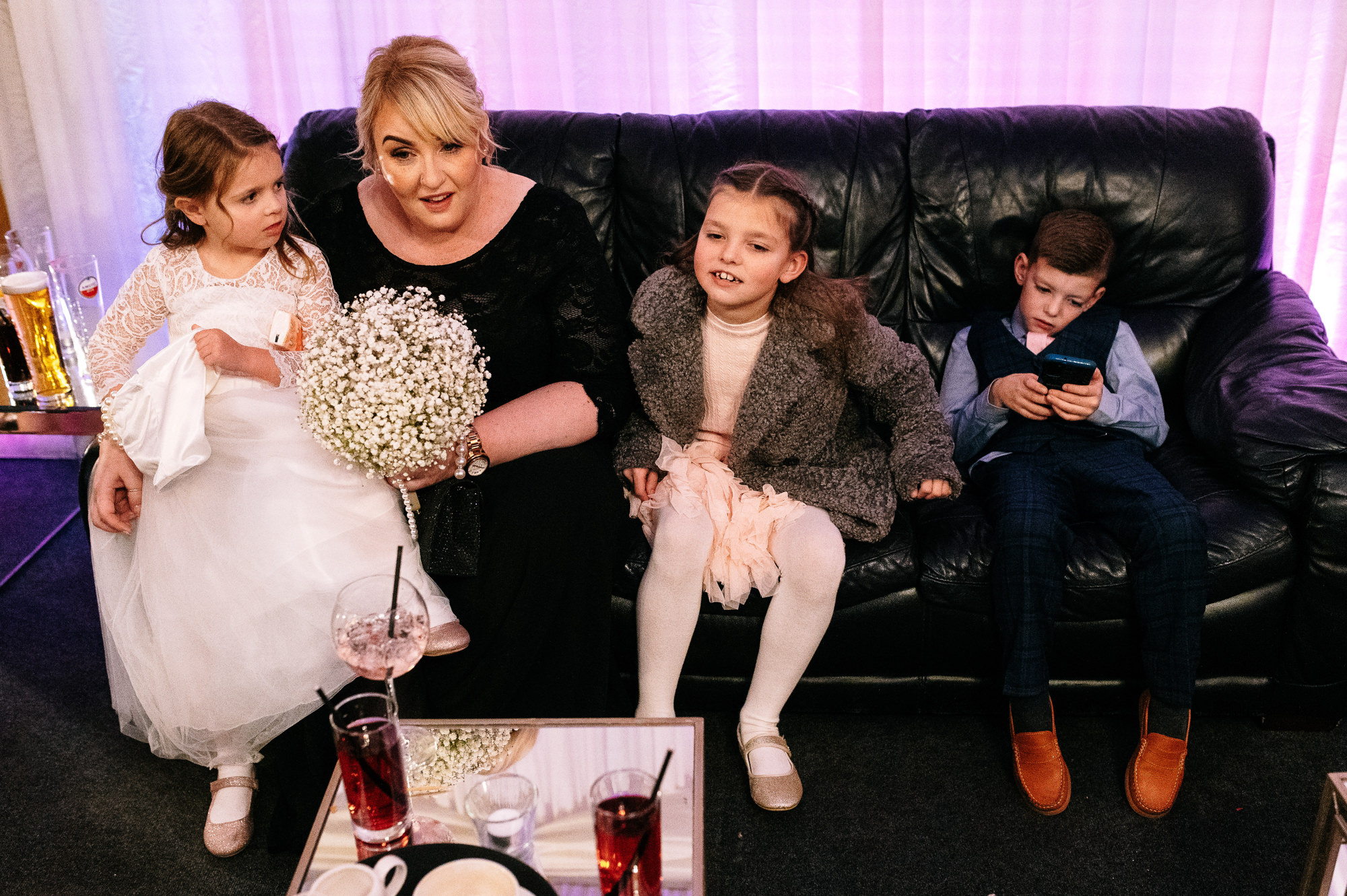 bridesmaid sat on a sofa with 3 kids