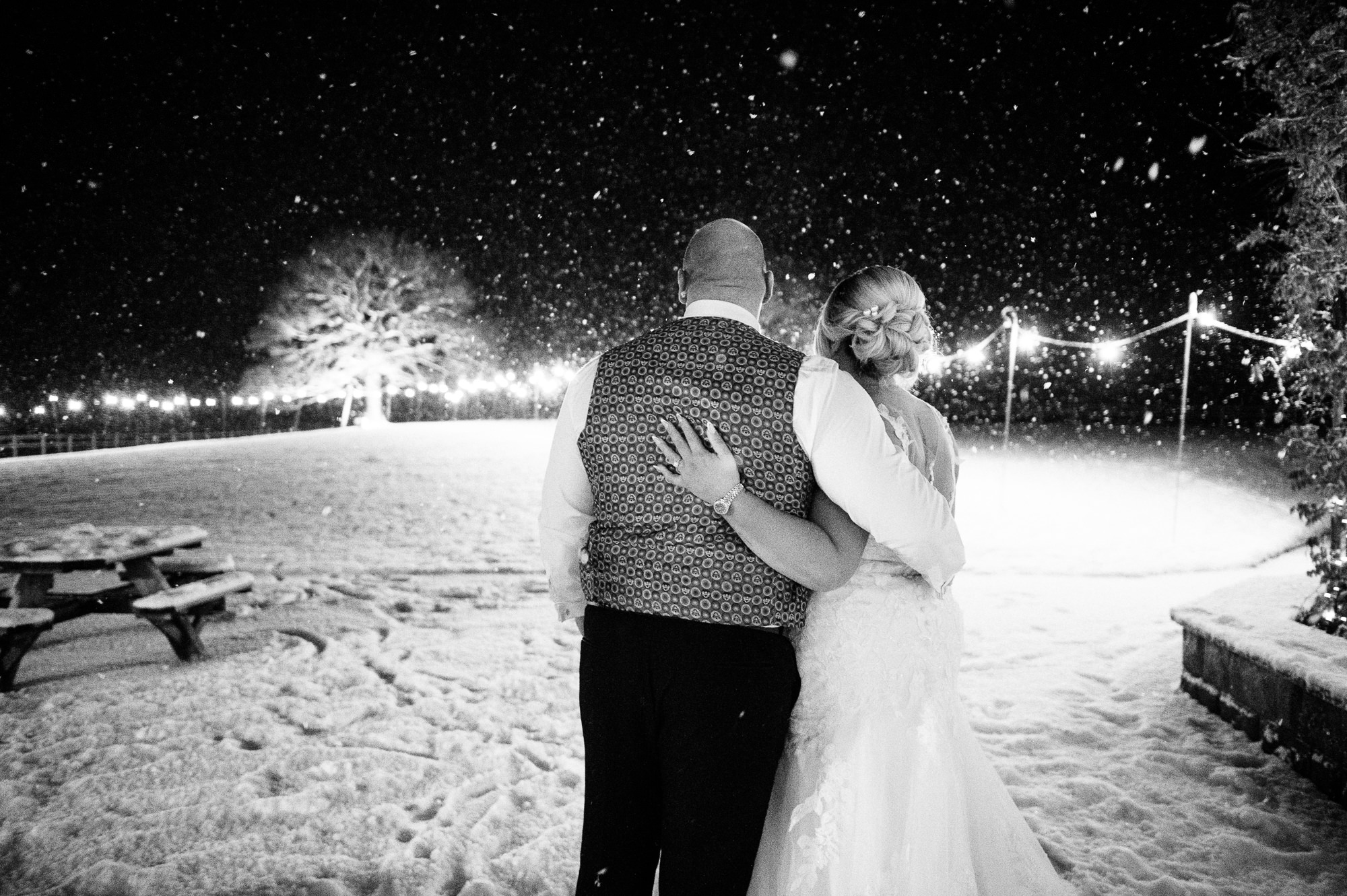 winter wedding couples portrait stood together looking at the snow