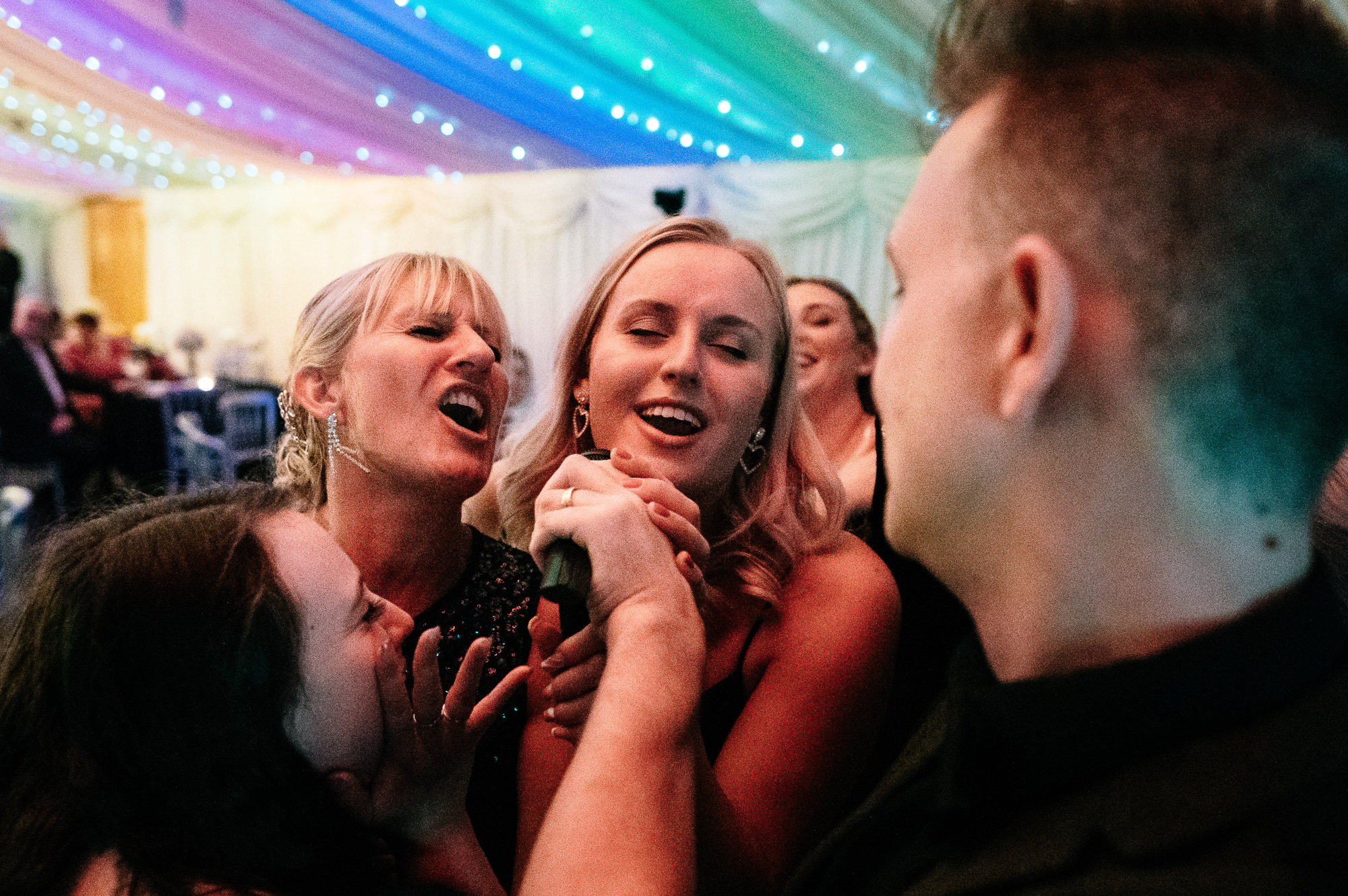 wedding guests singing into the mic on the dance floor