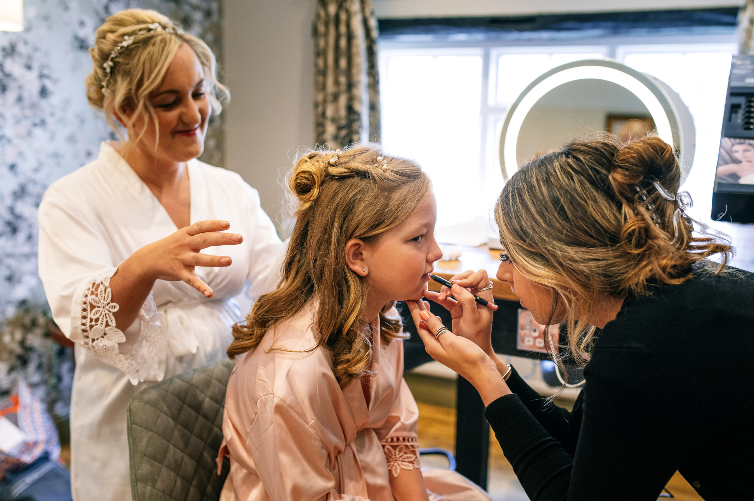 bride's daughter having her makeup done