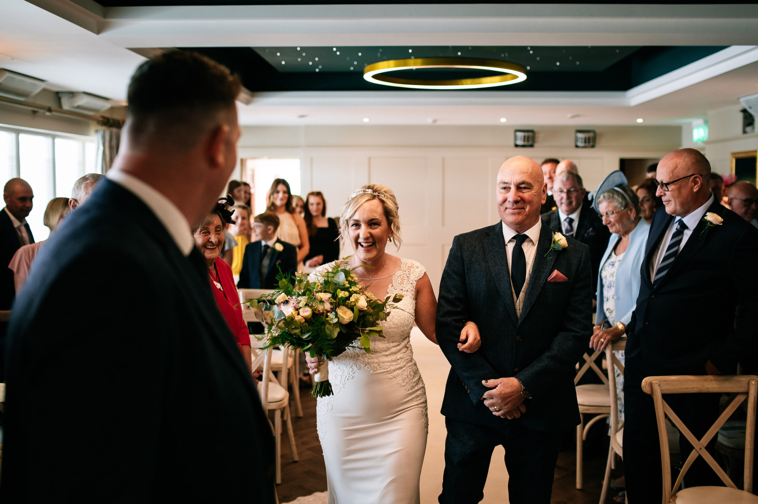 happy smiling bride walking down the aisle with her dad