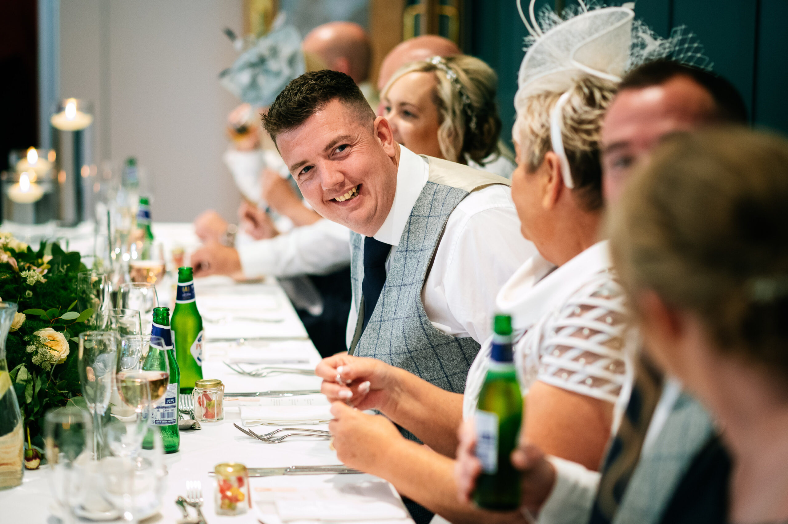 smiling groom looking down the top table