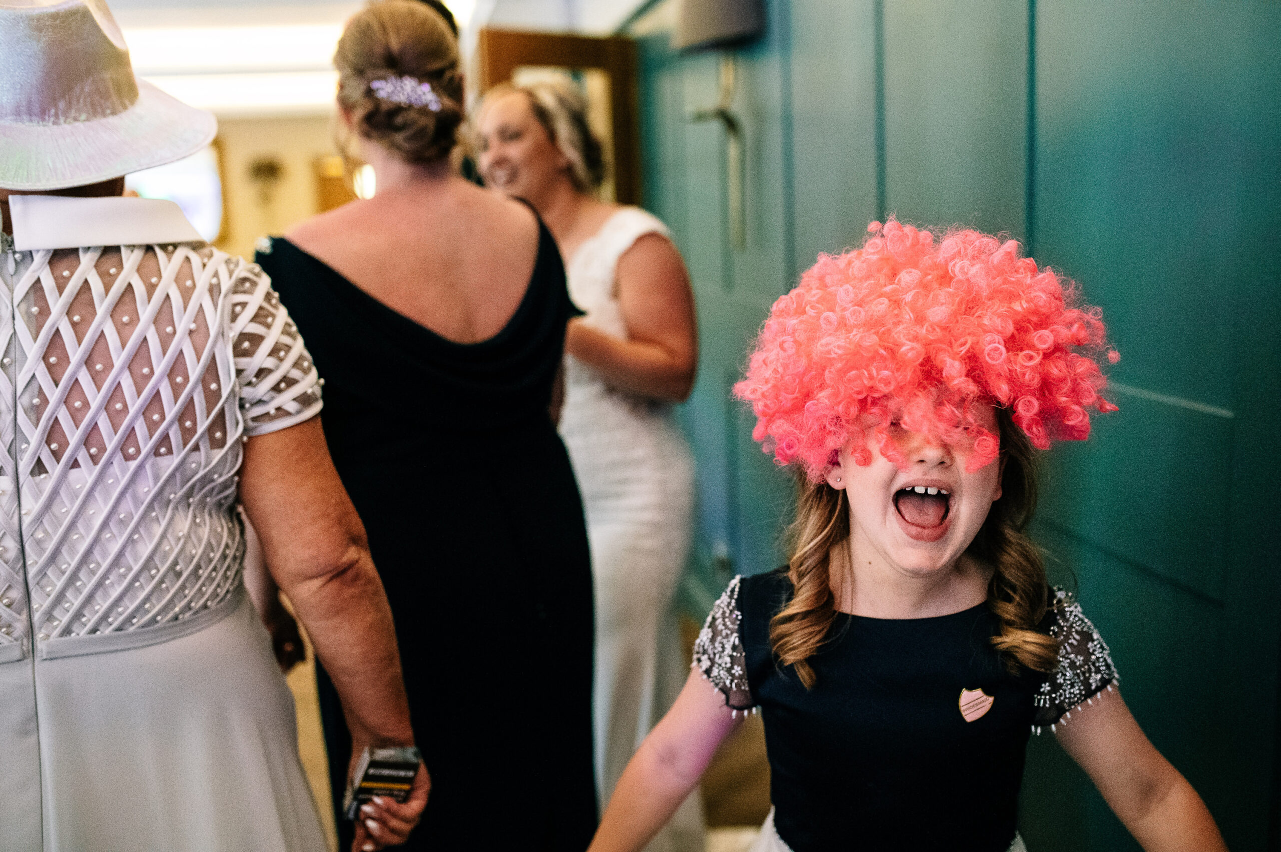 girl wearing a pink wig at wedding photo booth