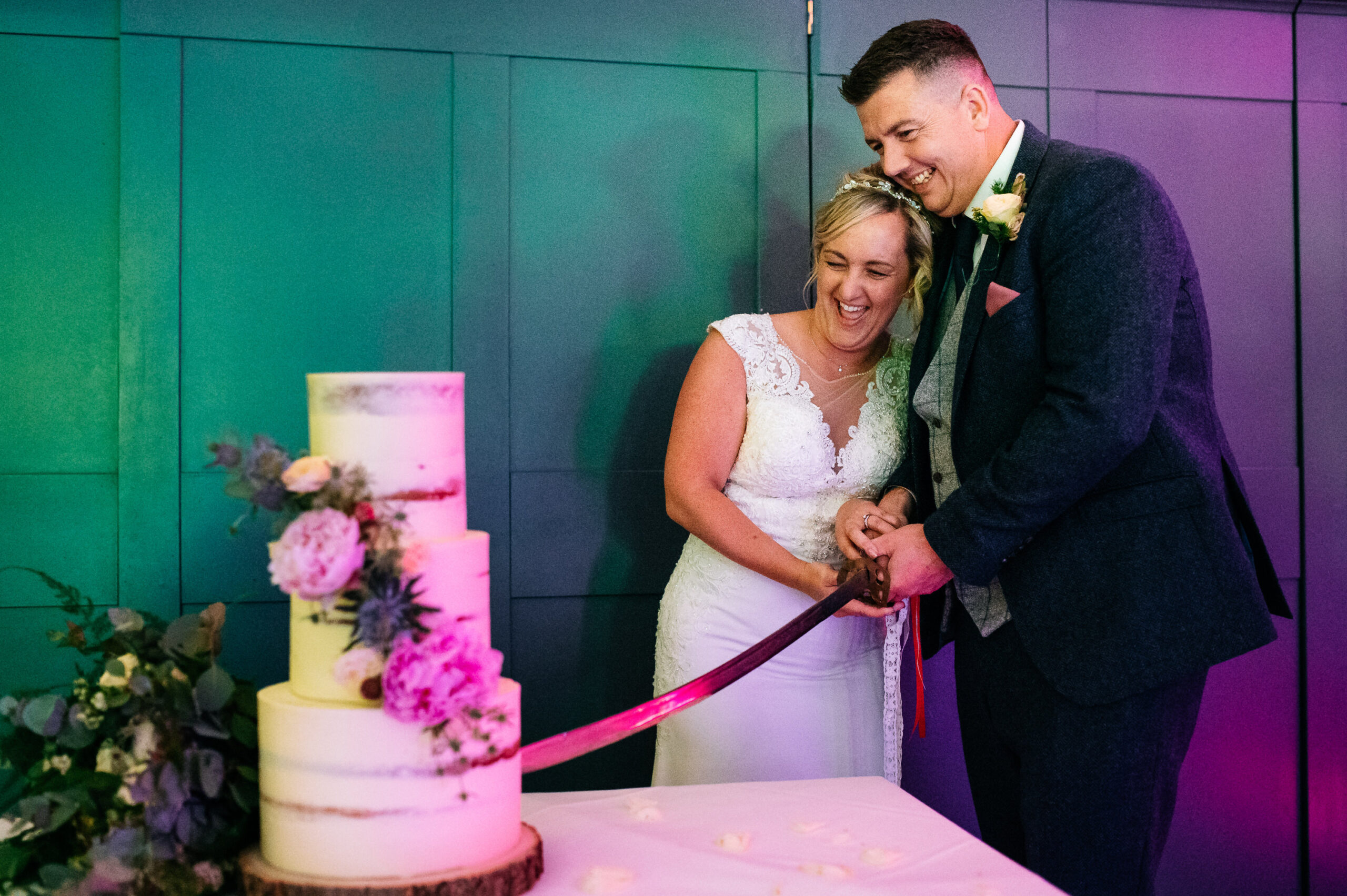 couple cut the cake with a sword