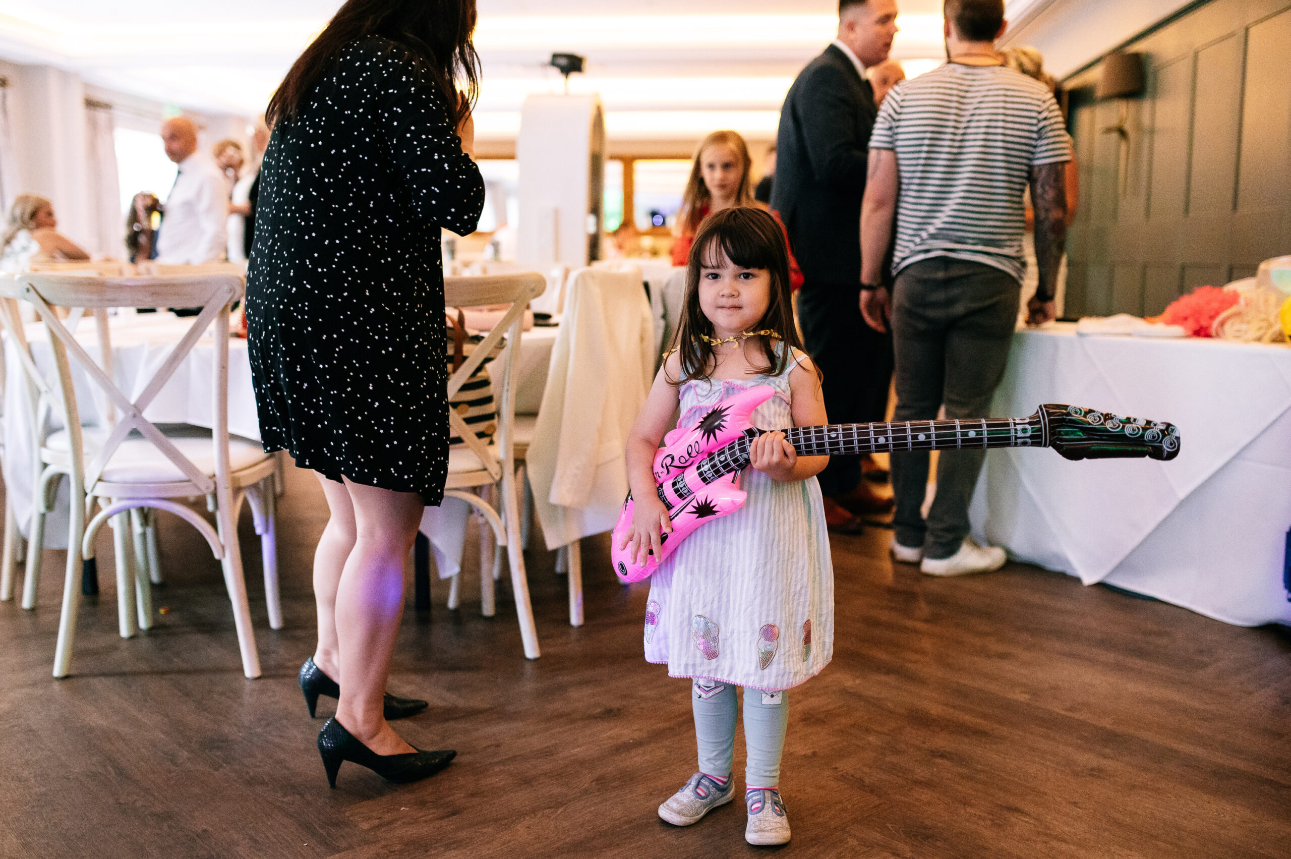 little girl holding inflatable guitar