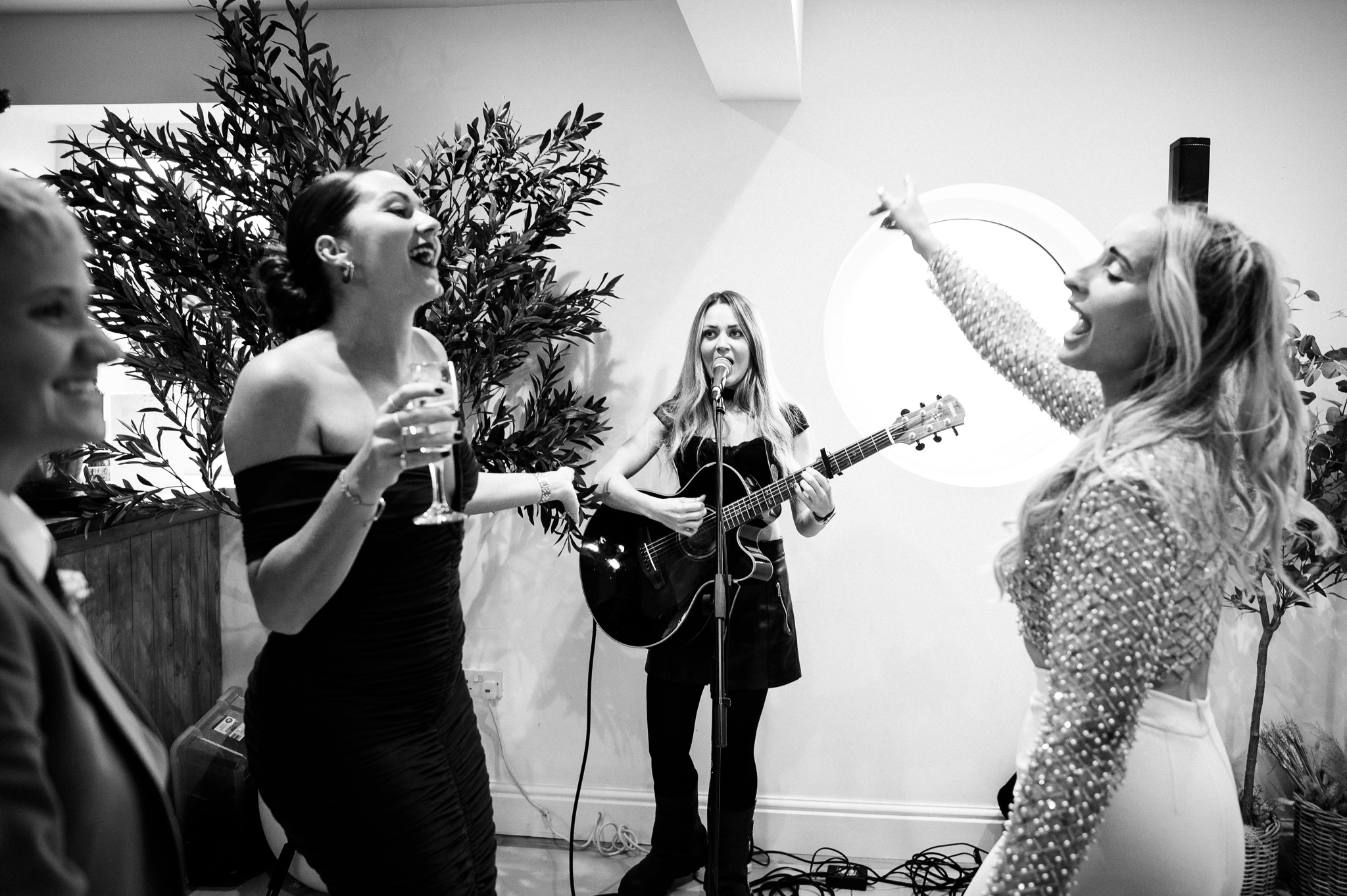 women dancing as a woman plays acoustic guitar behind them