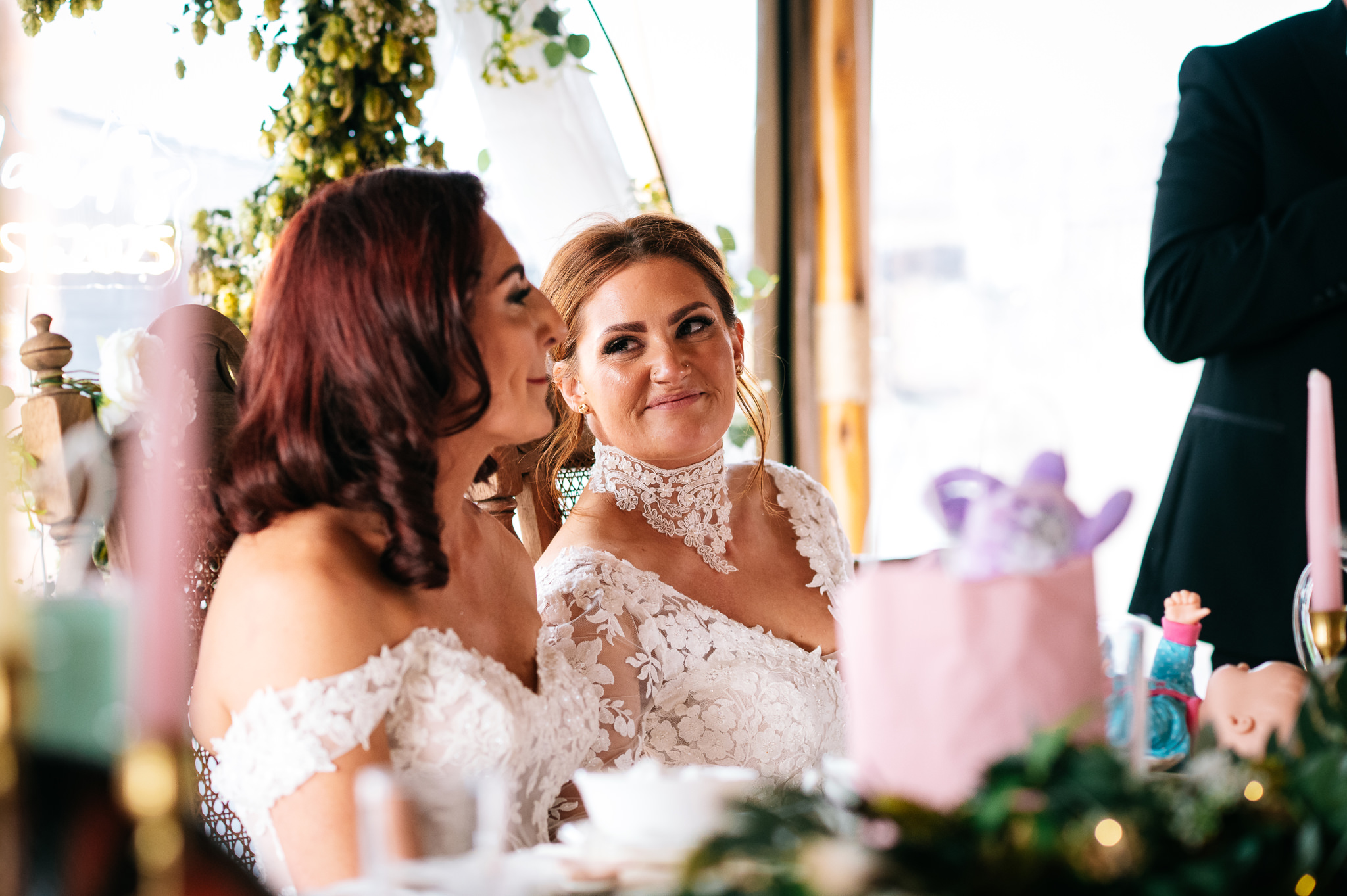 bride smiling lovingly at her wife during the wedding speeches