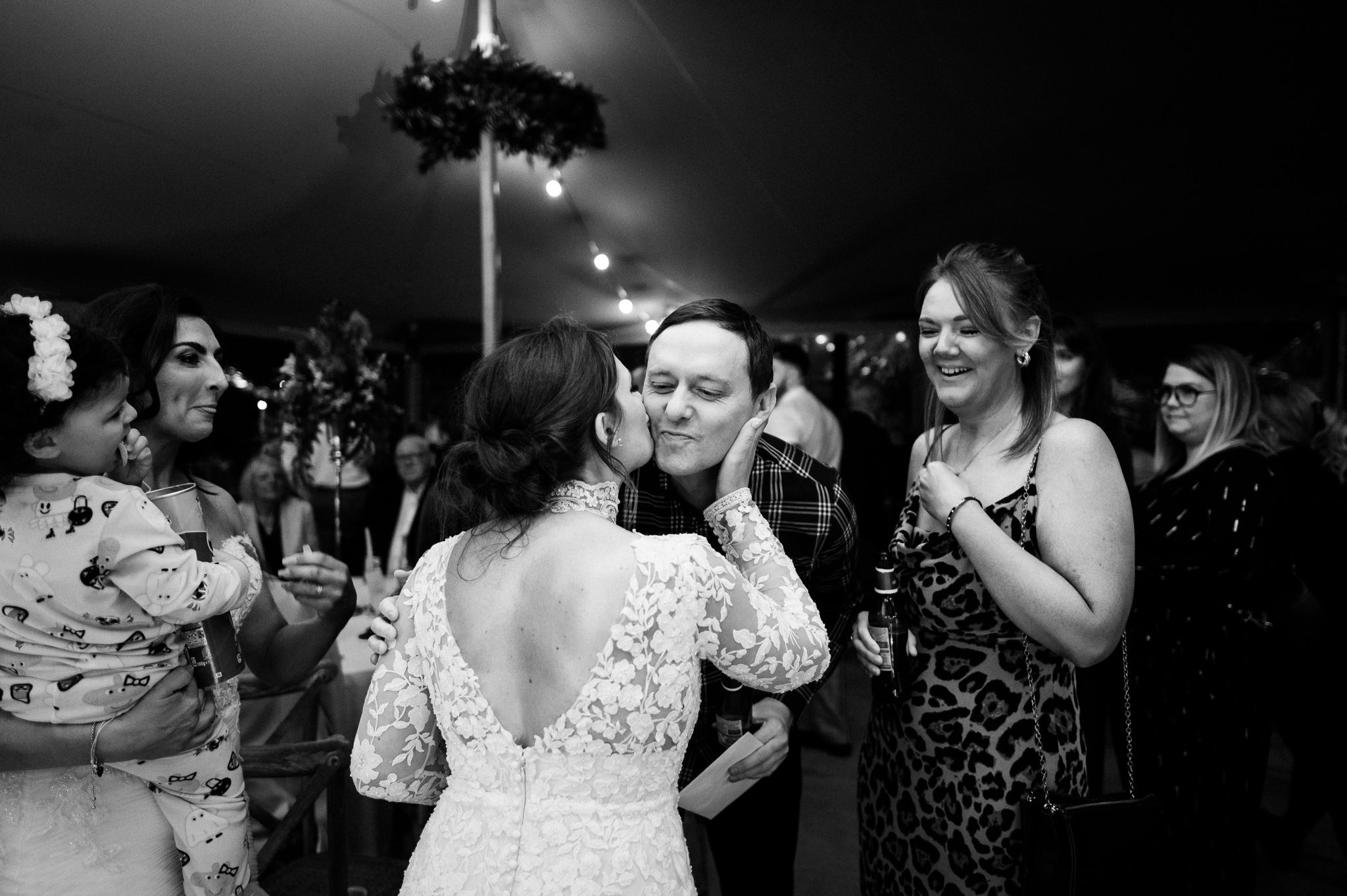 a bride greeting one of her evening guests with a kiss on the cheek