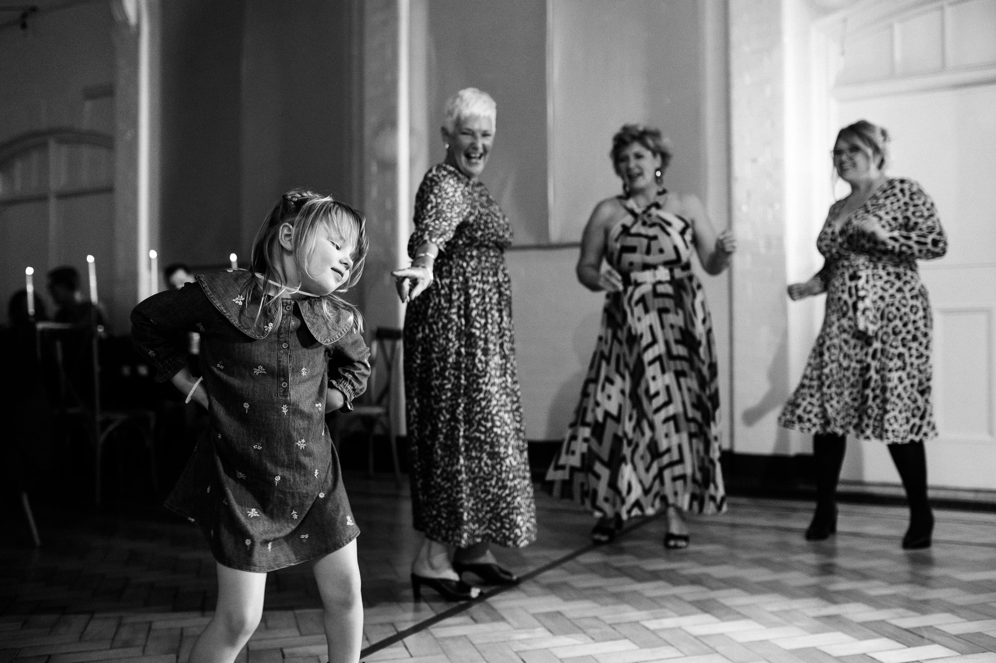 young girl dancing with older women laughing behind her