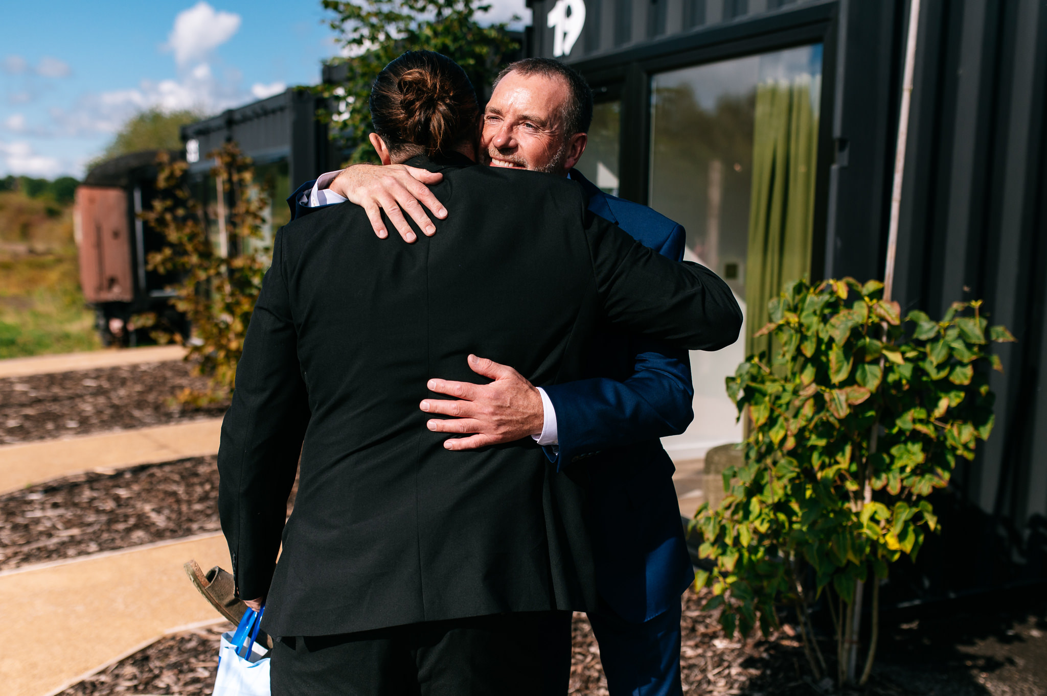 groom hugging guests as they arrive
