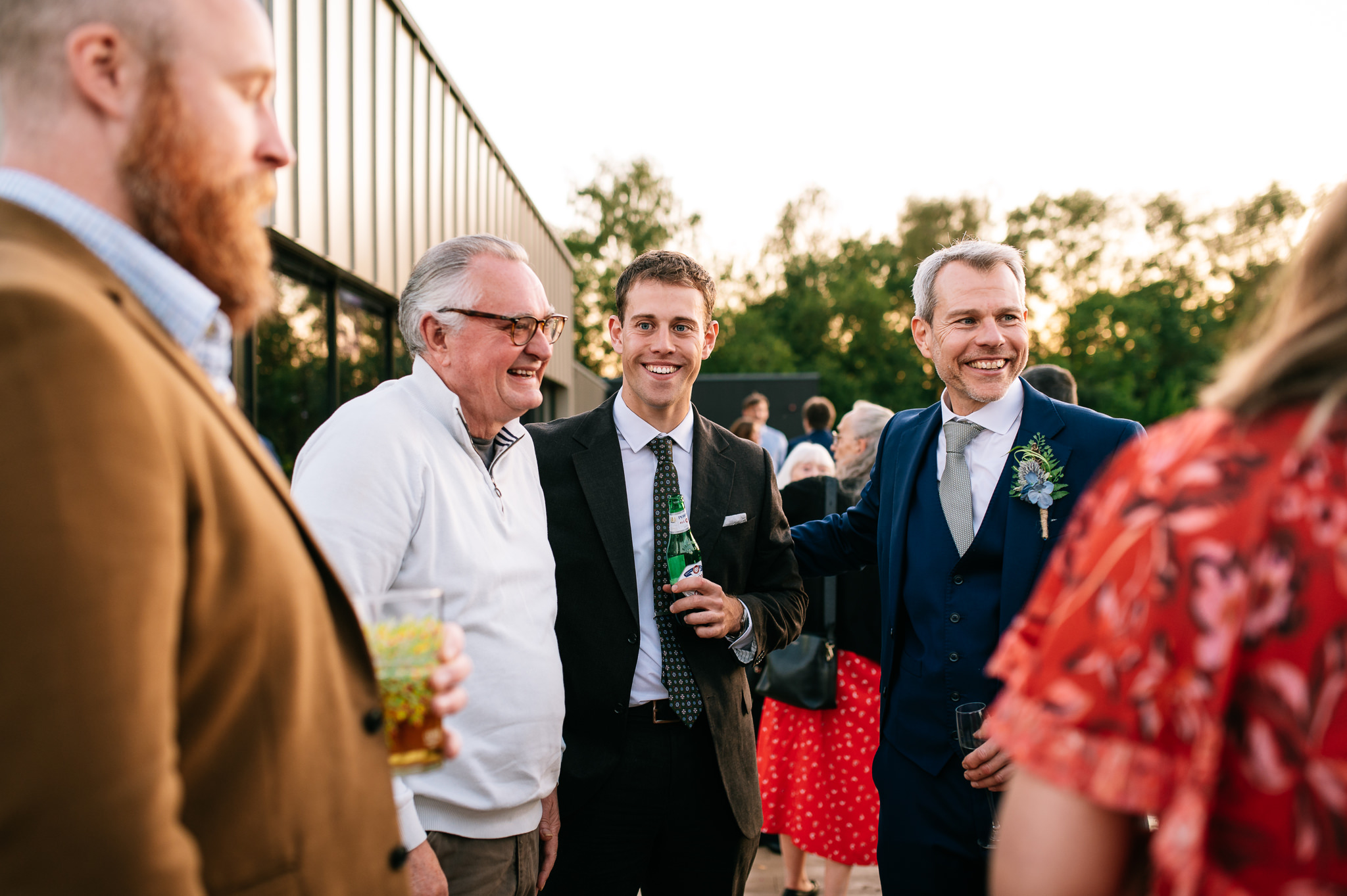 a group of happy wedding guests chatting outside