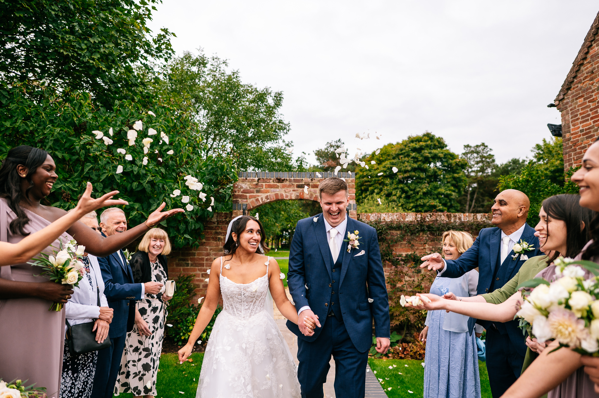 bride and groom walk through the confetti tunnel