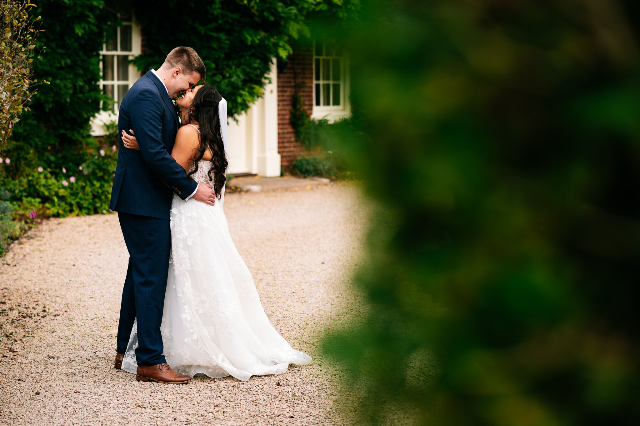 happily married bride and groom cuddling in front of the house at alrewas hayes