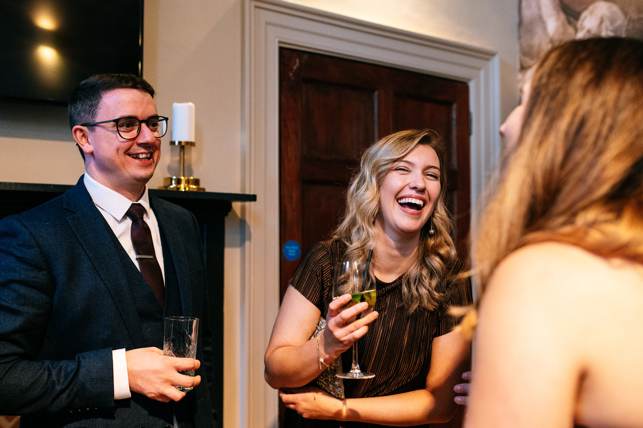 man and a woman stood together laughing with a friend