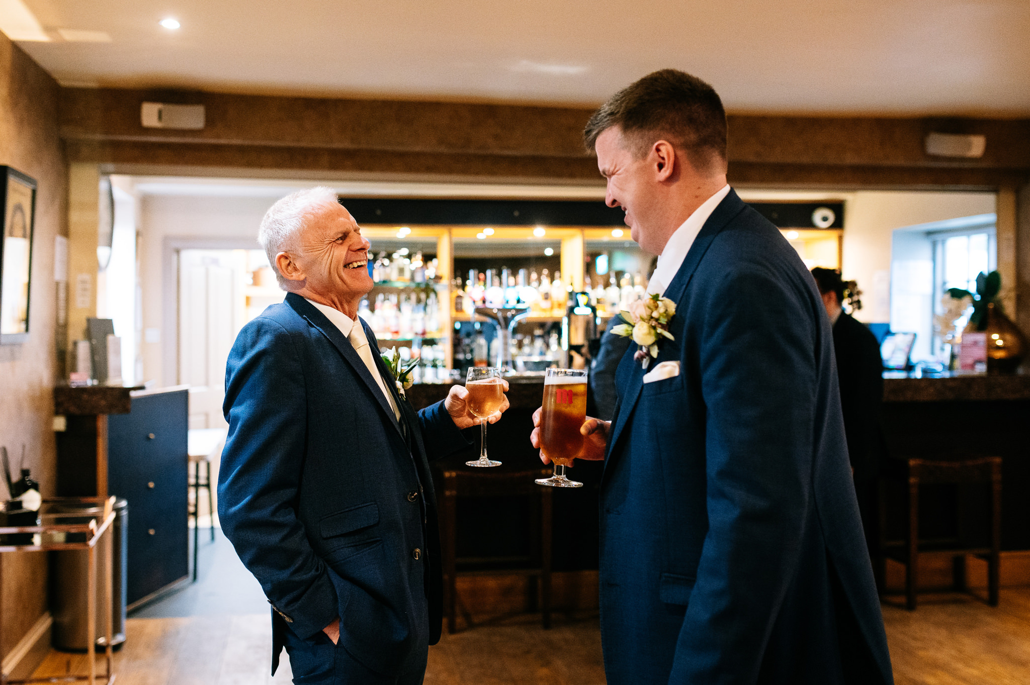 groom sharing a drink and a laugh with his dad