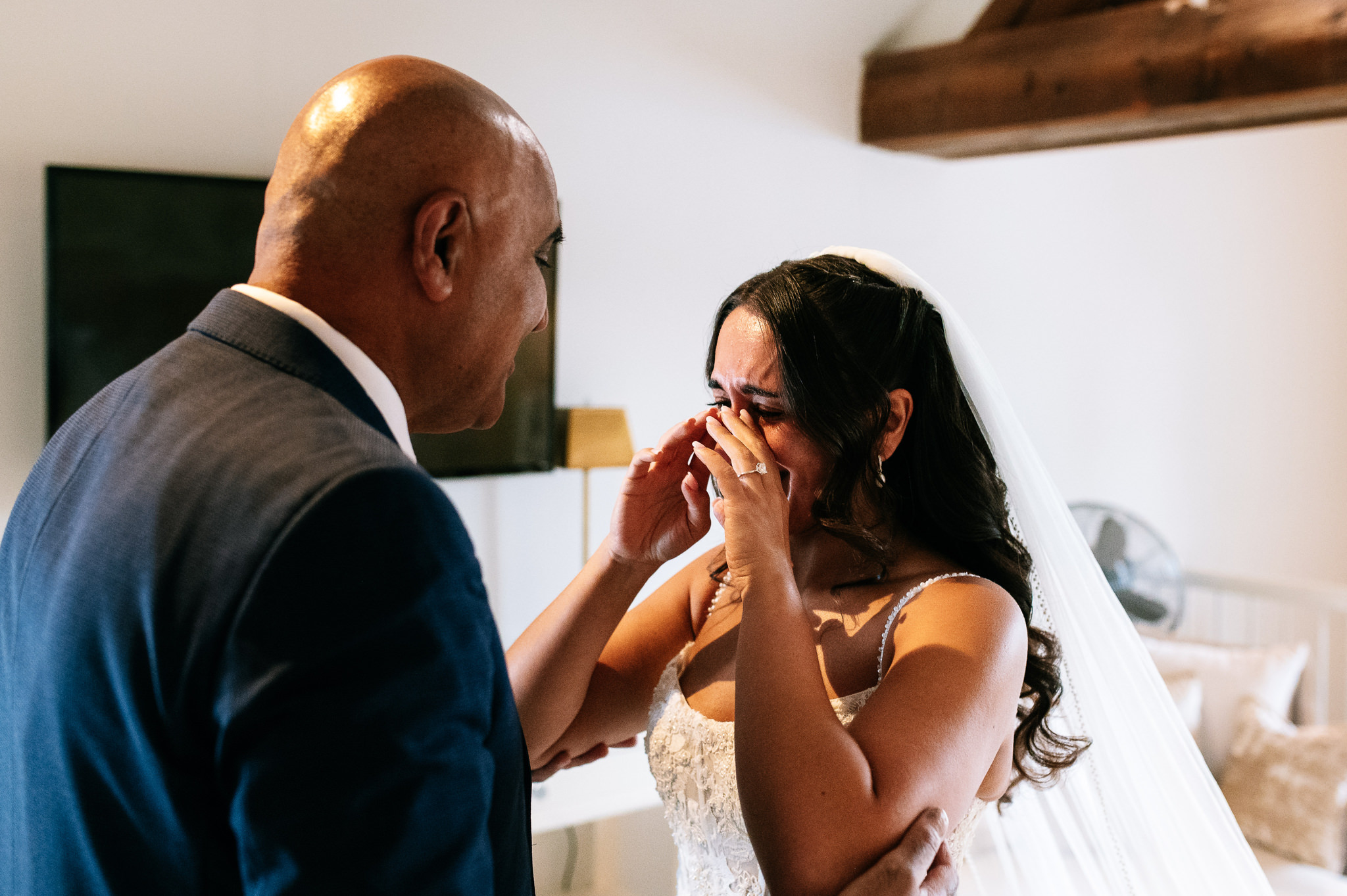 emotional bride wiping away tears after seeing her dad