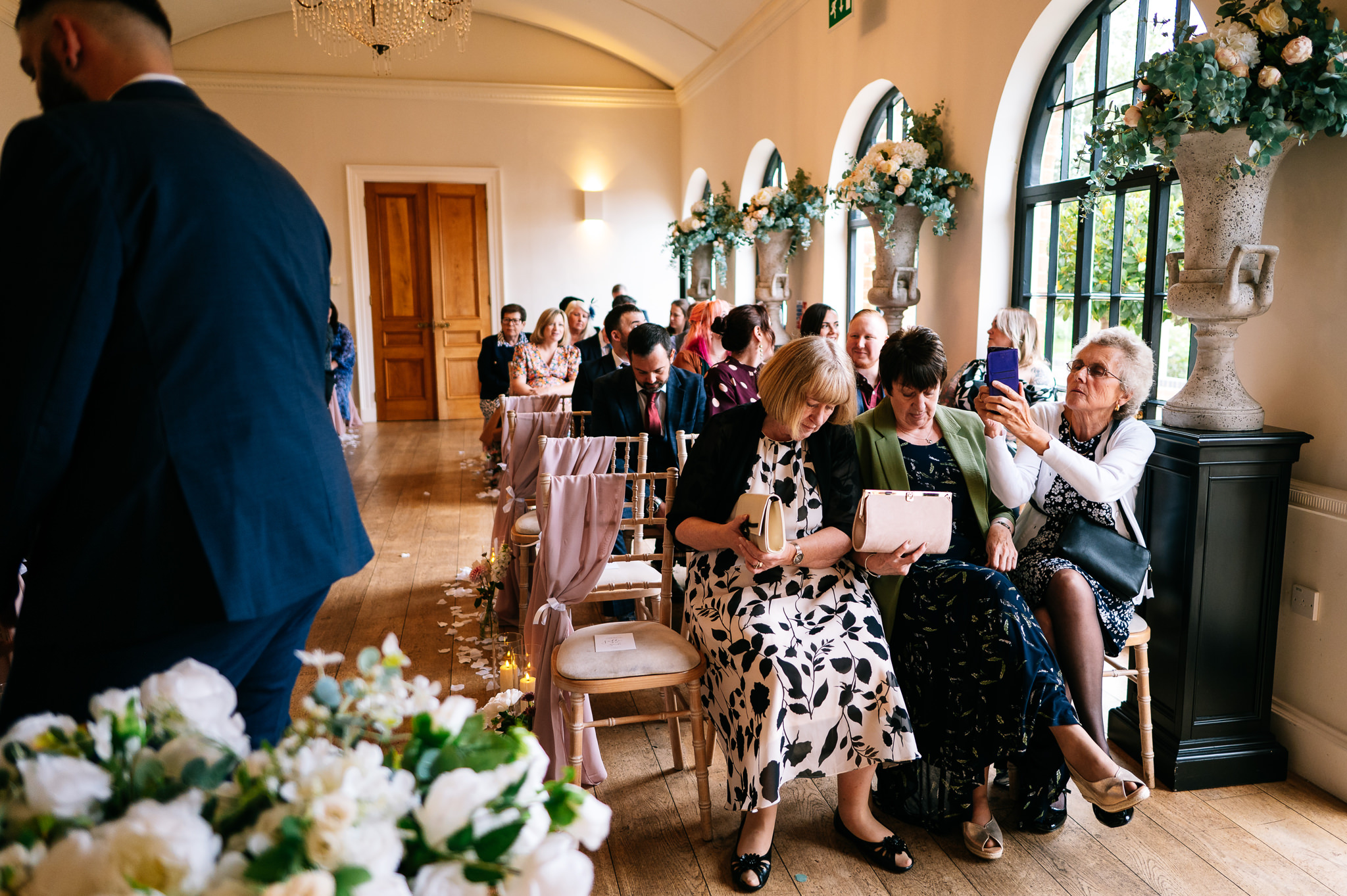 guest in the front row taking a photo of the groom