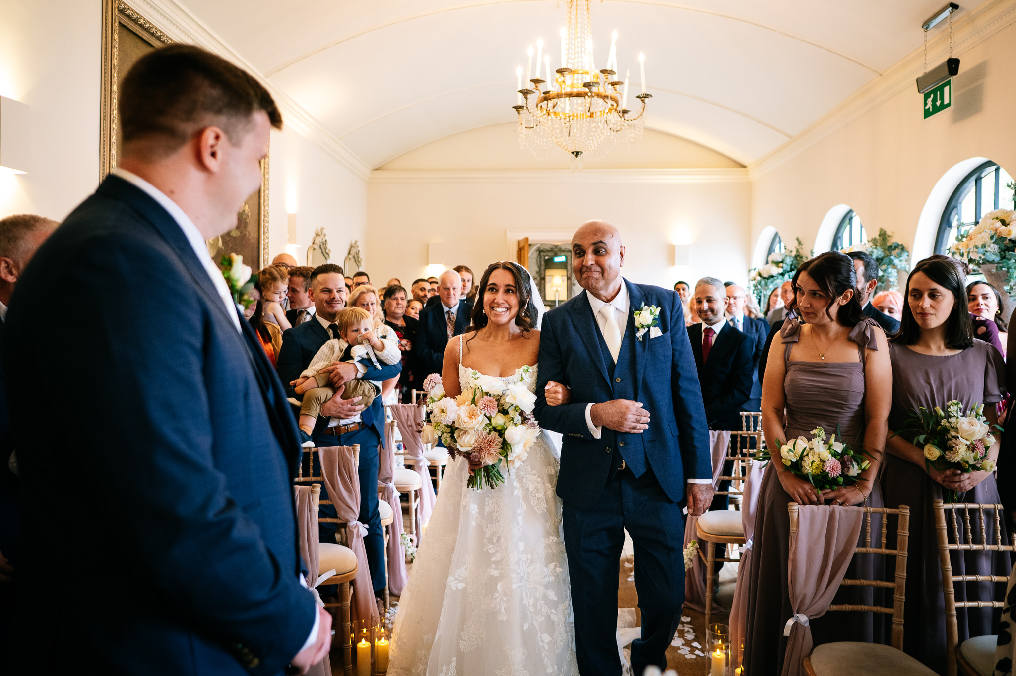 bride and her proud dad walking down the aisle together